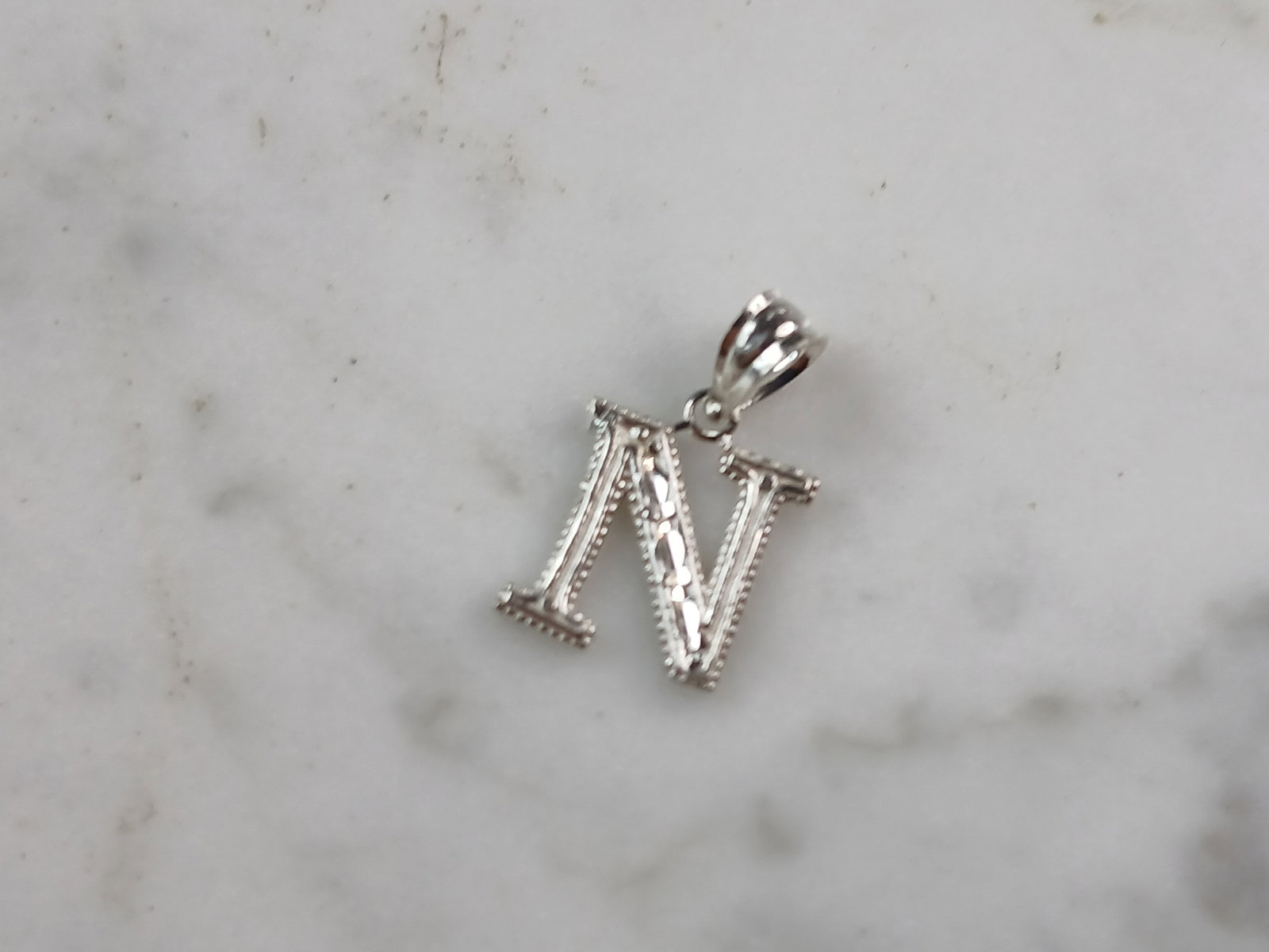 Womens Sterling Silver Initial Letter " N " Pendant: A WOMENS STERLING SILVER INITIAL LETTER "N" PENDANT. PENDANT WEIGHS 0.3g AND MEASURES 5/8" LONG BY 3/8" WIDE. MAKES A GREAT GIFT FOR THAT SOMEONE SPECIAL. ANY QUESTIONS, PLEASE ASK. BE SURE TO CHECK O