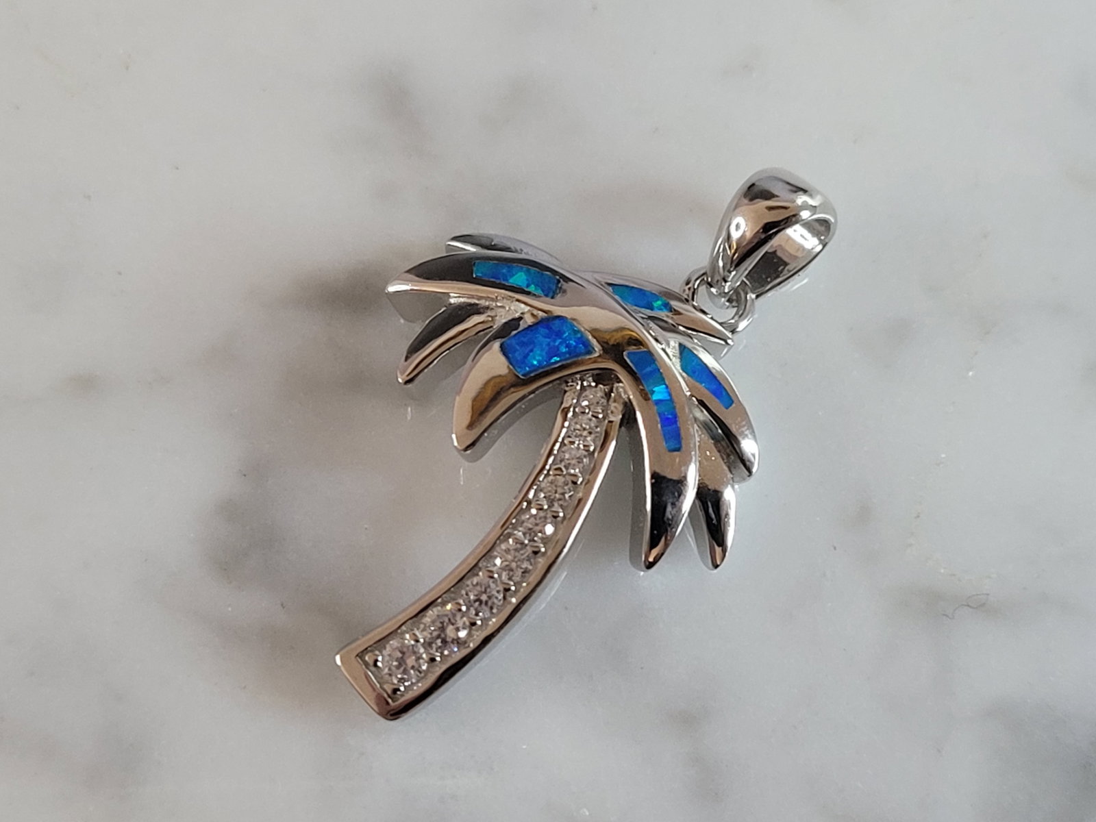 Womens Sterling Silver Blue Opal Beach Palm Tree Pendant: A WOMENS ESTATE STERLING SILVER BLUE OPAL PALM TREE PENDANT. NOT SURE IF STONES ARE REAL OR MAN MADE. THE PENDANT WEIGHS 3.2g AND MEASURES 1" LONG BY 5/8" WIDE. MAKES A GREAT GIFT FOR THAT SOMEONE SPE