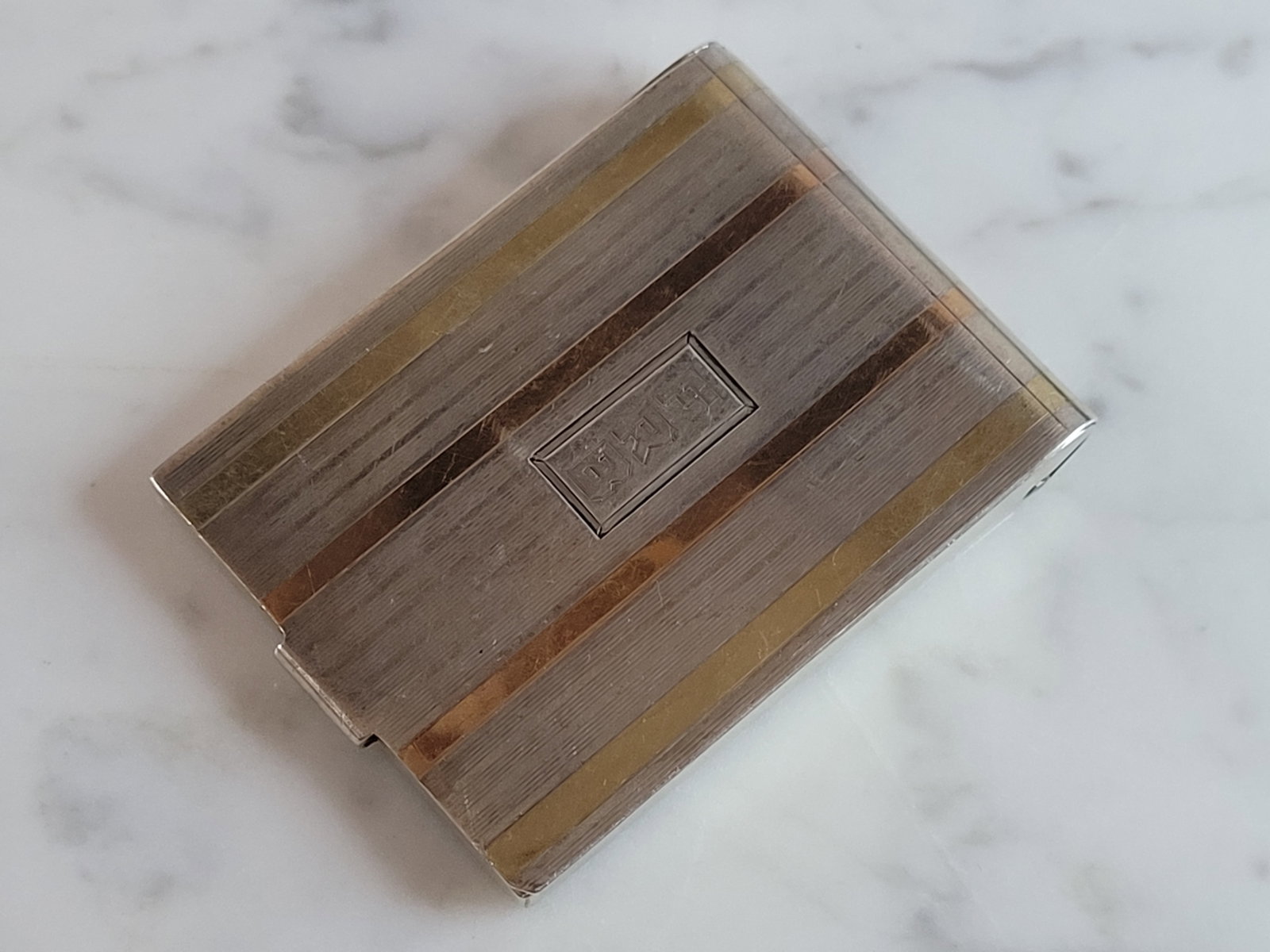 Antique Deco 14k Gold Inlay Sterling Silver Matchbook Case 30.8g: An antique art deco matchbook case made of sterling silver with 14k gold inlay. Matchbook case measures 2 1/4" by 1 3/4", and weighs 30.8g. Condition is good but it does have some tiny flaws on the ba