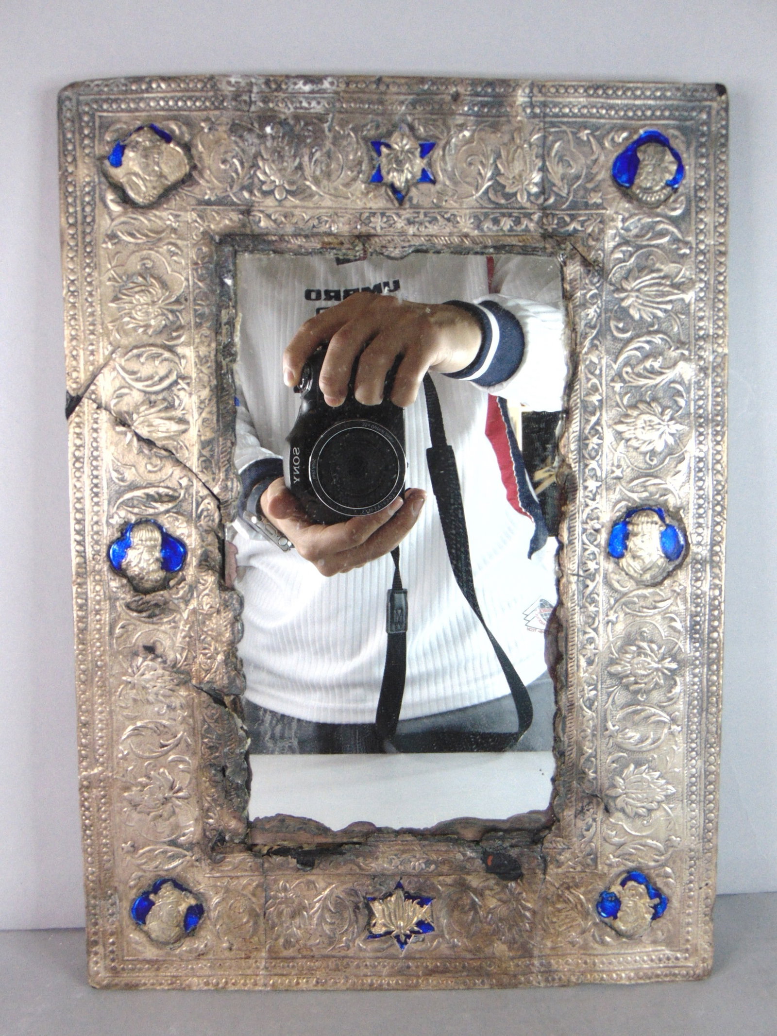 Vintage Antique Decorative Coin Silver Islamic Wall Mirror: A BEAUTIFUL VINTAGE ANTIQUE DECORATIVE COIN SILVER ISLAMIC WALL MIRROR. PIECE MEASURES ABOUT 12 1/4" BY 8 3/4". MIRROR HAS DAMAGE ON THE FRONT AS SEEN IN THE PICTURES, WOULD BE BUYING AS IS. MIRROR IS
