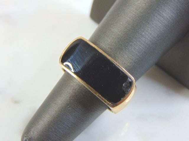 Womens Vintage Estate 14k Yellow Gold & Onyx Ring: A WOMENS VINTAGE ESTATE 14K YELLOW GOLD AND ONYX RING. THE RING WEIGHS 12.4g AND IS A SIZE 7. RING HAS SOME MINOR BLEMISH ON THE CORNER OF THE STONE, BUYING AS IS. ANY QUESTIONS PLEASE DO NOT HESITATE
