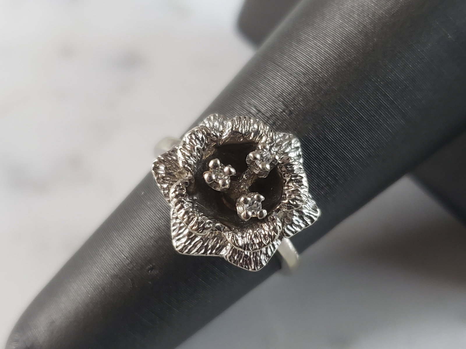 Womens Vintage Estate 14K White Gold Diamond Flower Ring: A WOMEN'S VINTAGE ESTATE 14K WHITE GOLD FLOWER RING WITH DIAMONDS . THE RING IS A SIZE 5.25, AND WEIGHS 3.8g. THERE ARE ABOUT .03cts. RING IS MARKED ON THE INSIDE "14K". THIS IS A BEAUTIFUL, IMPRESSIV