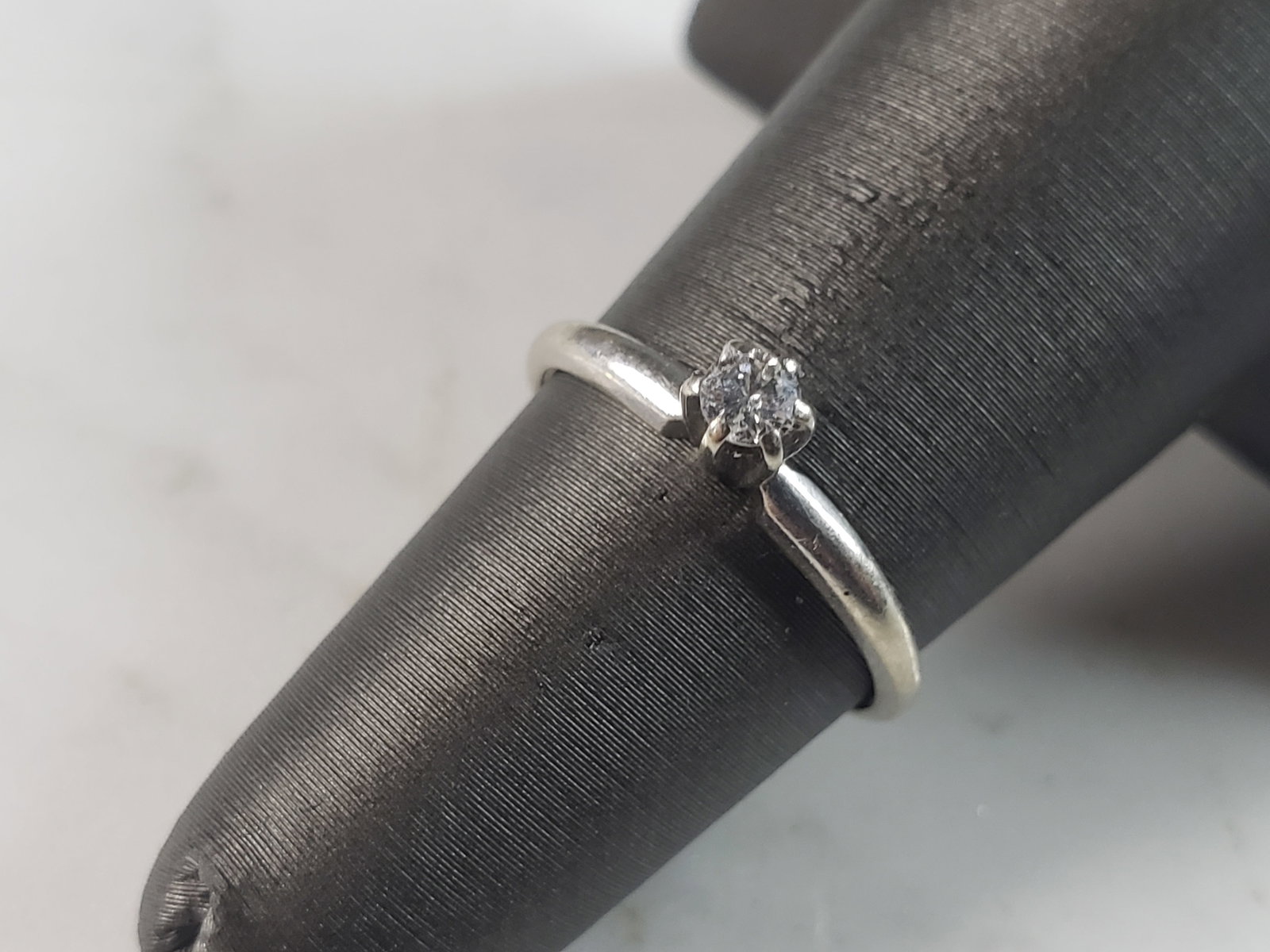 Womens Vintage Estate 14k White Gold Solitaire .10ct Diamond Ring: A WOMENS 14K WHITE GOLD RING WITH A BEAUTIFUL .10ct DIAMOND. THE RING WEIGHS 1.2g. THE SIZE OF THE RING IS A 4.75. RING IS MARKED "14K". THE DIAMOND HAS A BEAUTIFUL SPARKLE TO IT, AND WOULD MAKE A LOV