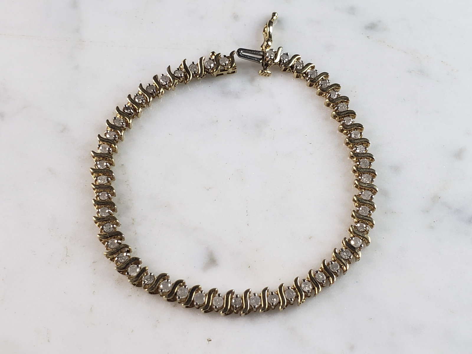 Womens Vintage Estate 10K Gold Diamond Tennis Bracelet: A WOMENS VINTAGE ESTATE 10K WOMENS TENNIS BRACELET WITH ABOUT 1.41cts OF DIAMONDS. THE BRACELET MEASURES 7" LONG BY 3/16" WIDE. BRACELET WEIGHS 7.2g. WOULD MAKE A GREAT GIFT FOR THAT SPECIAL SOMEONE. 