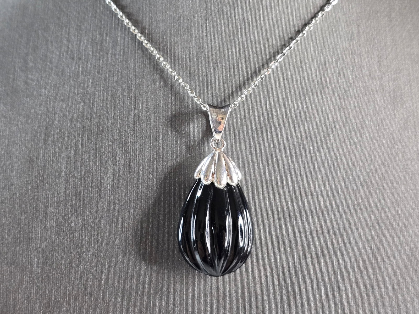 Womens Vintage Estate Sterling Silver Scalloped Onyx Pendant Necklace: A WOMENS VINTAGE ESTATE STERLING SILVER SCALLOPED ONYX PENDANT WITH NECKLACE. PENDANT WITH NECKLACE WEIGHS 6.5g. THE PENDANT MEASURES 1 1/4" LONG BY 1/2" WIDE. THE NECKLACE MEASURES 18" LONG. NOT SURE