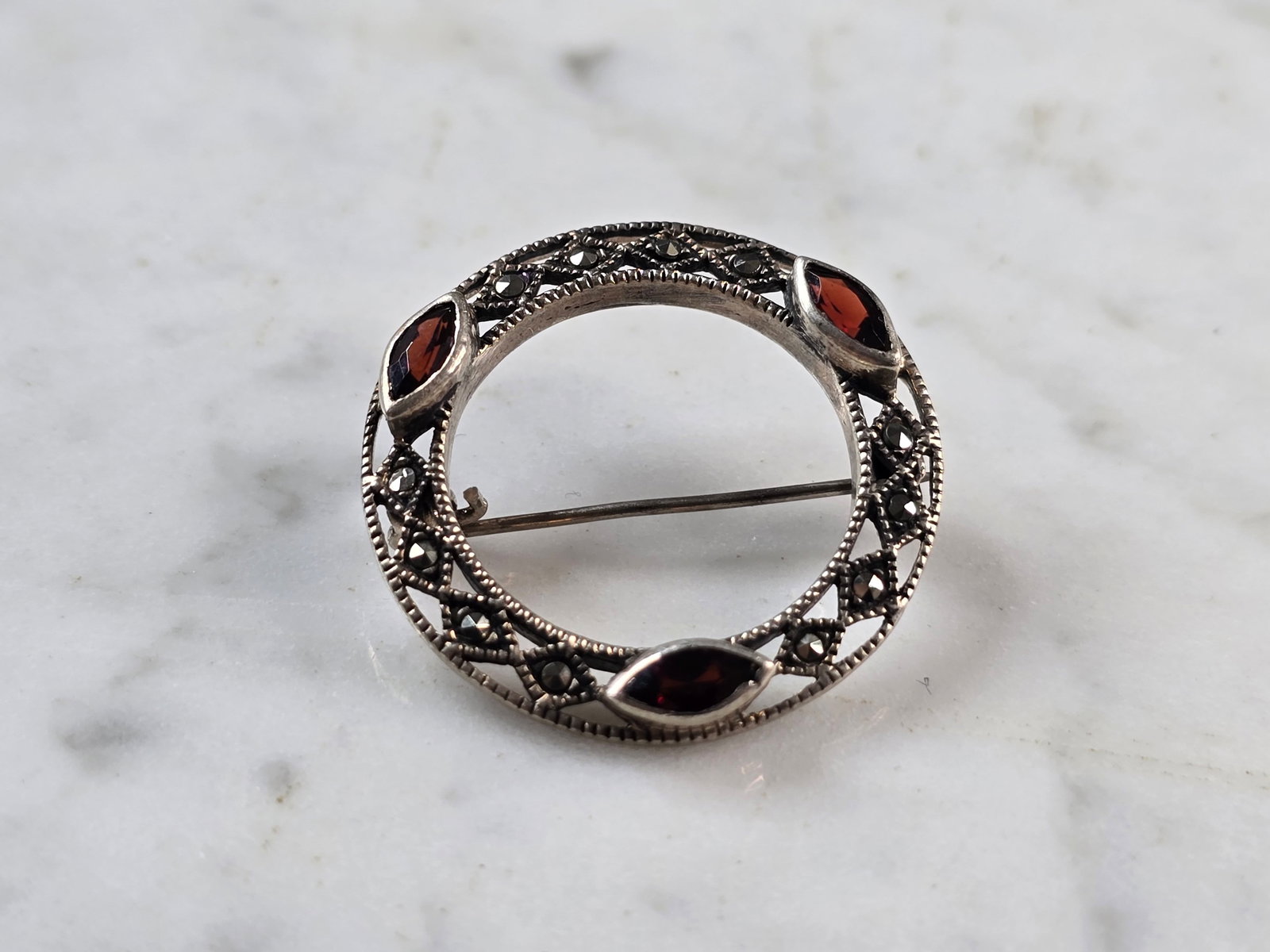 Womens Vintage Estate Sterling Silver Garnet Brooch: A WOMENS VINTAGE ESTATE STERLING SILVER BROOCH THAT MEASURES 1 1/8" IN DIAMETER AND WEIGHS 4.7g. NOT SURE IF THE STONES ARE NATURAL OR MAN MADE. ANY QUESTIONS, PLEASE DO NOT HESITATE TO ASK. BE SURE T