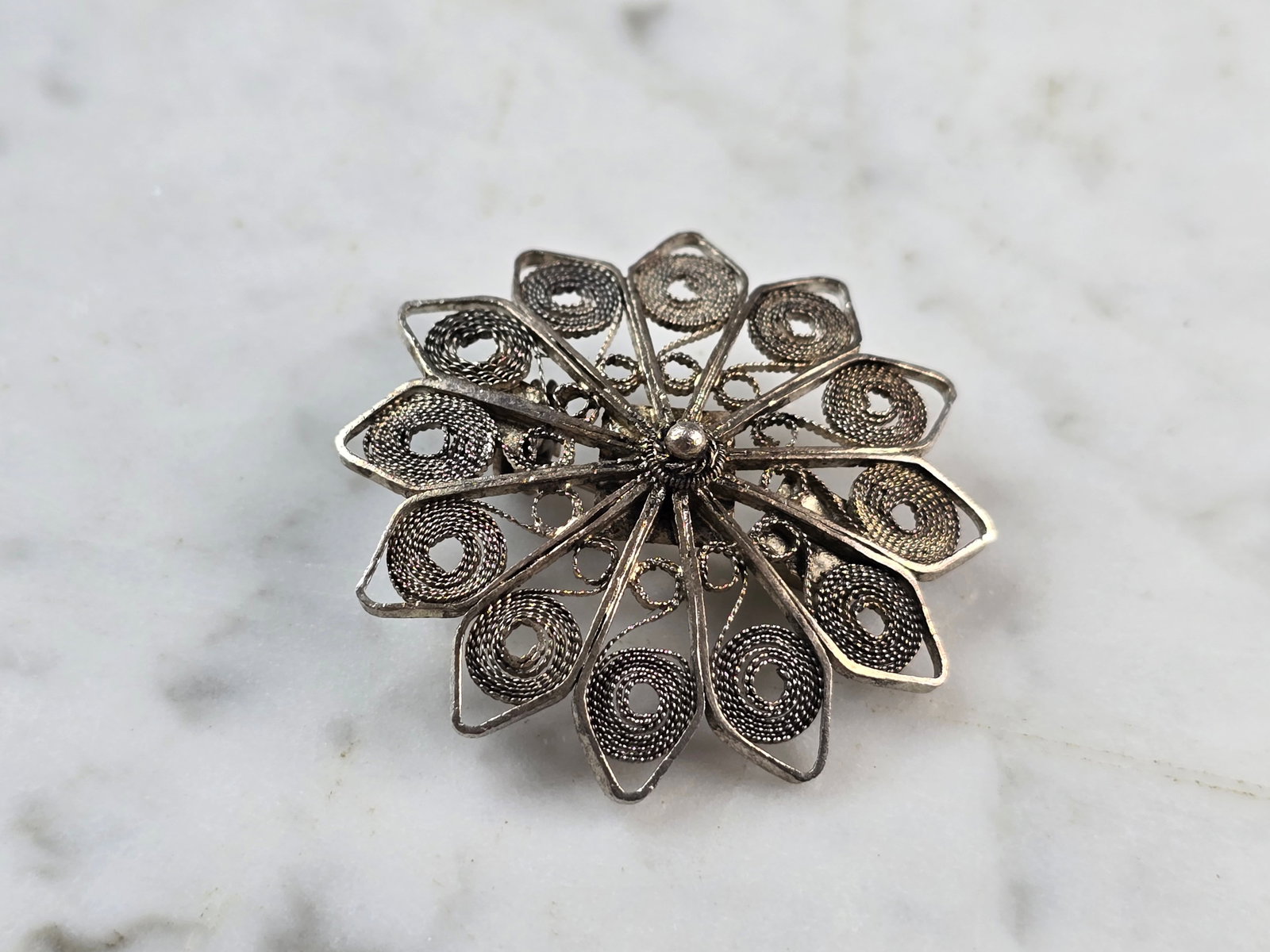 Womens Vintage Estate Sterling Silver Filigree Brooch: A WOMENS VINTAGE ESTATE STERLING SILVER FILIGREE FLORAL BROOCH. THE TOTAL WEIGHT OF THE BROOCH IS 5.7g. THE BROOCH MEASURES 1 1/2" IN DIAMETER. MAKES A GREAT GIFT FOR THAT SPECIAL SOMEONE. ANY QUESTIO