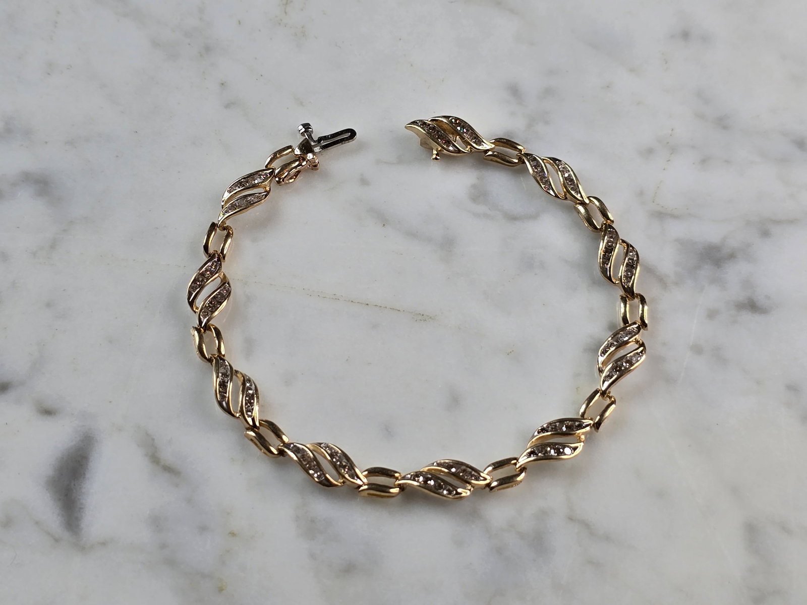 Womens Vintage Estate 10K Gold Diamond Tennis Bracelet: A WOMENS VINTAGE ESTATE 10K DIAMOND TENNIS BRACELET. THE BRACELET MEASURES 7 1/8" LONG BY 1/4" AND WEIGHS 6.7g. THERE ARE 80 TINY DIAMONDS IN THIS BRACELET. WOULD MAKE A GREAT GIFT FOR THAT SPECIAL SO