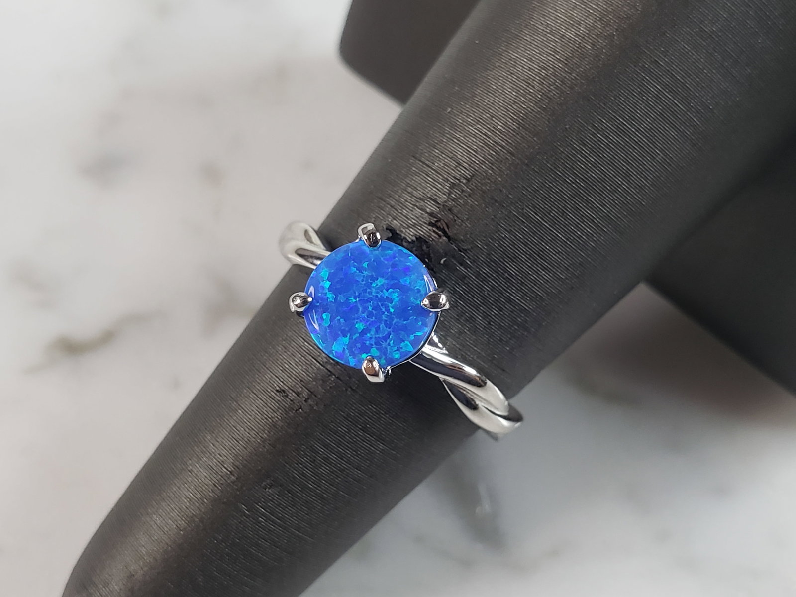 Womens Estate Sterling Silver Modernist Blue Opal Ring: A WOMENS ESTATE STERLING SILVER MODERNIST BLUE OPAL COLORED RING. THE RING IS A SIZE 7.25, AND WEIGHS 2.6g. WIDTH OF RING MEASURES 1/4". NOT SURE IF STONE IS NATURAL OR MAN MADE. THE RING MAKES A BEAU