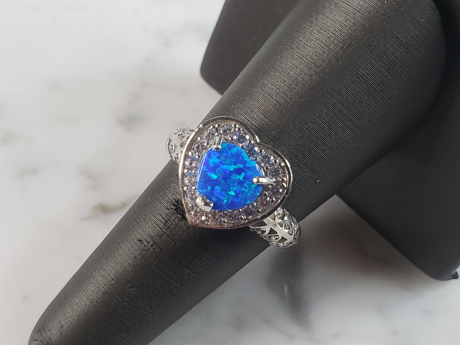 Womens Estate Sterling Silver Modernist Blue Opal & CZ Heart Ring: A WOMENS ESTATE STERLING SILVER MODERNIST BLUE OPAL COLORED HEART RING. THE RING IS A SIZE 7.25 AND WEIGHS 3.7g. WIDTH OF RING MEASURES 1/2". NOT SURE IF STONE IS NATURAL OR MAN MADE. THE RING MAKES A