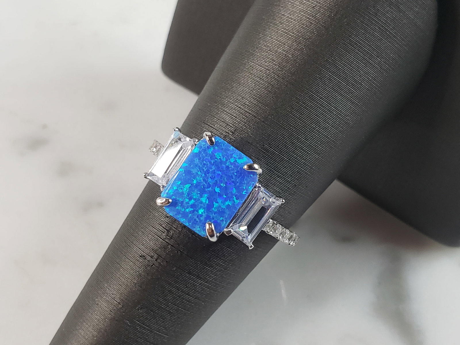 Womens Estate Sterling Silver Modernist Blue Opal & CZ Ring: A WOMENS ESTATE STERLING SILVER MODERNIST BLUE OPAL COLORED RING. THE RING IS A SIZE 7.25 AND WEIGHS 2.5g. WIDTH OF RING MEASURES 3/8". NOT SURE IF STONE IS NATURAL OR MAN MADE. THE RING MAKES A BEAUT