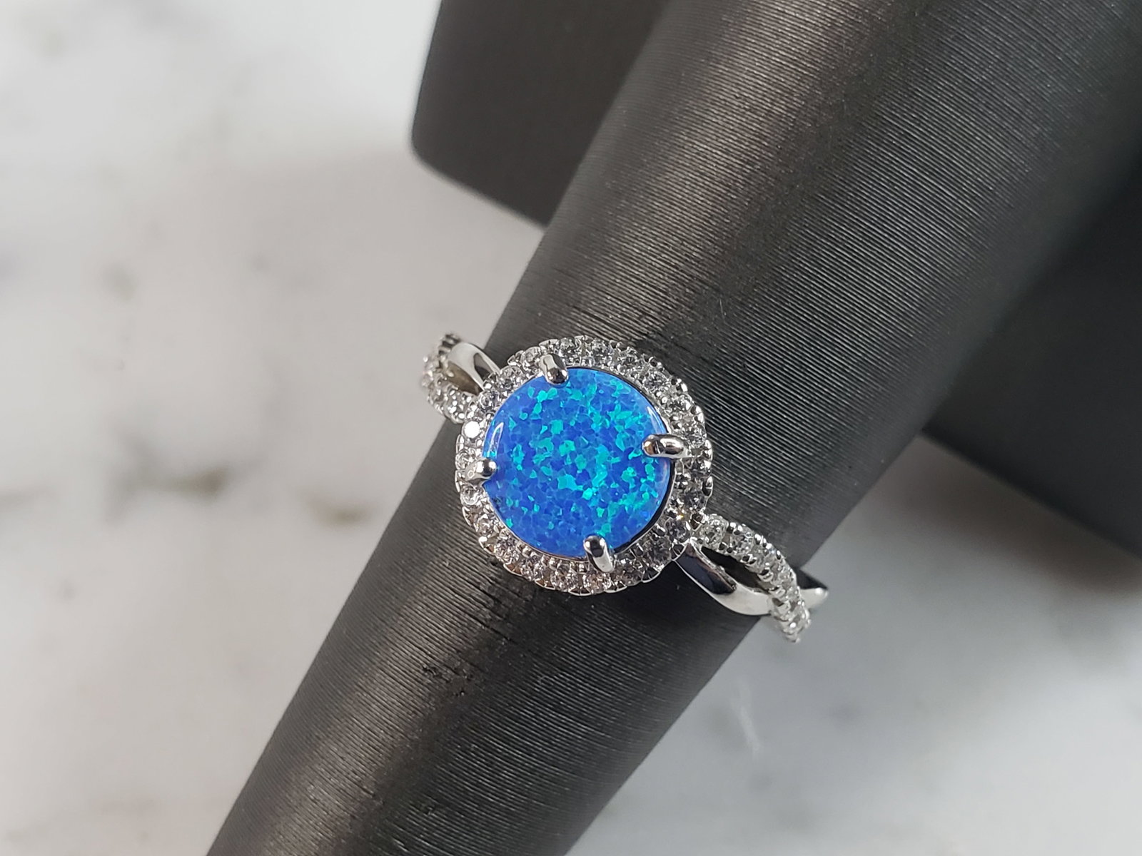 Womens Estate Sterling Silver Modernist Blue Opal & CZ Ring: A WOMENS ESTATE STERLING SILVER MODERNIST BLUE OPAL COLORED RING. THE RING IS A SIZE 7.25 AND WEIGHS 3.3g. WIDTH OF RING MEASURES 3/8". NOT SURE IF STONE IS NATURAL OR MAN MADE. THE RING MAKES A BEAUT