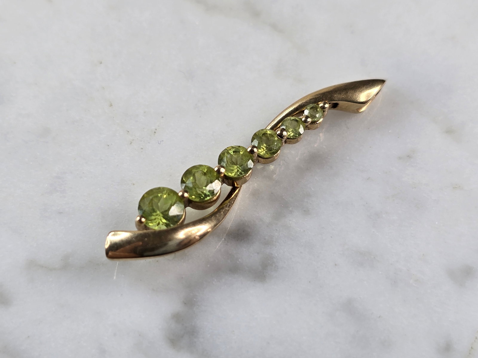 Womens Vintage Estate 10K Yellow Gold Modernist Peridot Pendant: A WOMENS VINTAGE ESTATE 10K YELLOW GOLD MODERNIST PERIDOT PENDANT. THE PENDANT WEIGHS 1.9g. AND MEASURES 1 1/4" LONG BY 1/4" WIDE. NOT SURE IF THE STONES ARE NATURAL OR MAN MADE. ANY QUESTIONS, PLEASE