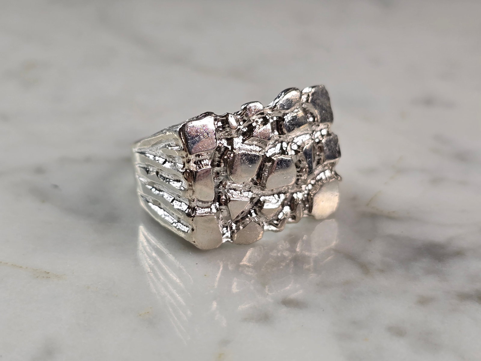 Mens Vintage Estate Sterling Silver Nugget Style Ring: A MENS VINTAGE ESTATE STERLING SILVER NUGGET STYLE RING. THE RING WEIGHS 8.9g AND IS A SIZE 11.5. THE WIDTH OF THE RING IS 5/8". THIS RING WOULD BE A WONDERFUL GIFT FOR THAT SPECIAL SOMEONE. ANY QUEST