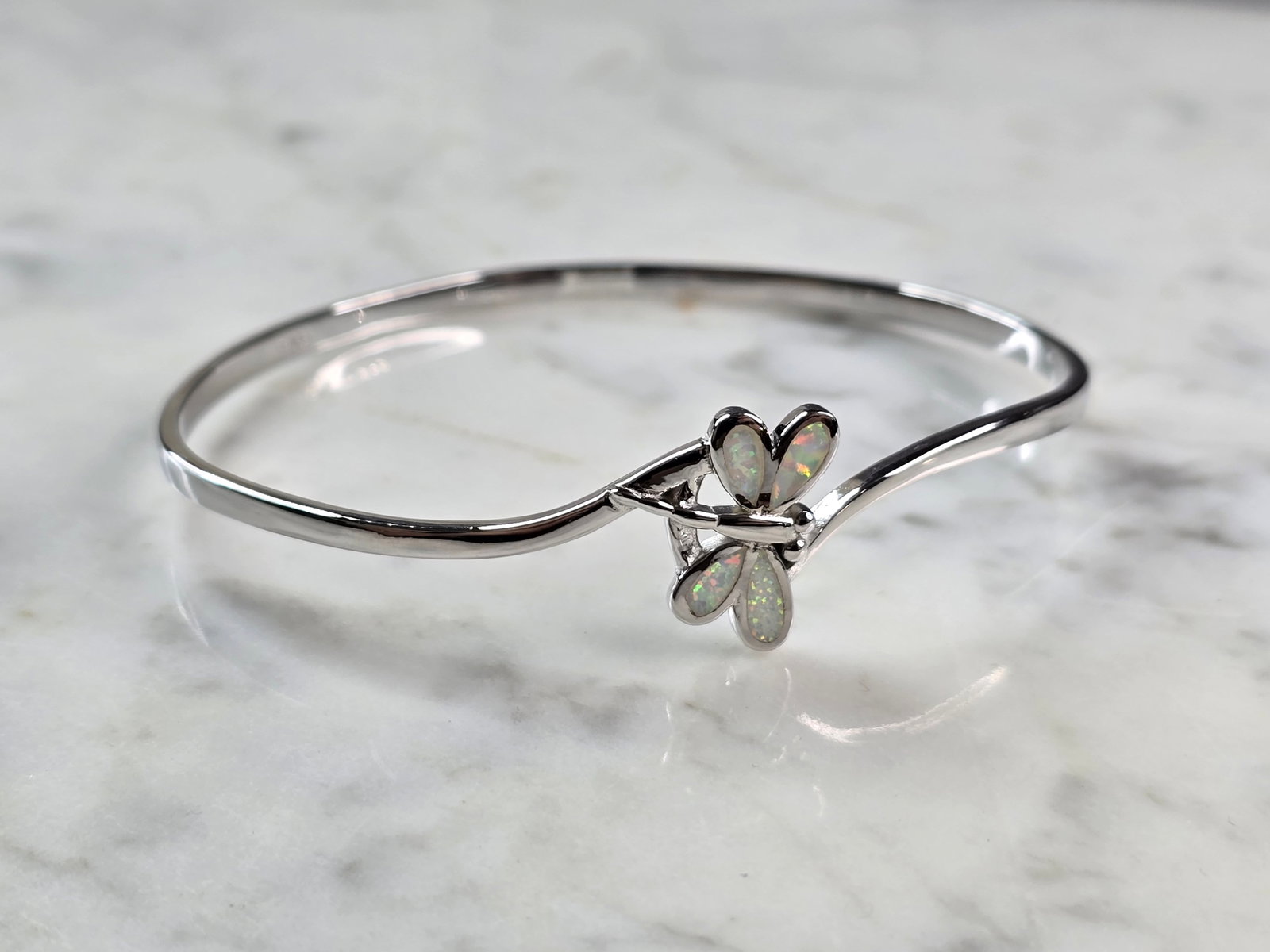 Womens Sterling Silver Opal Dragonfly Bangle Bracelet: A WOMENS STERLING SILVER MODERNIST OPAL COLORED DRAGONFLY BANGLE BRACELET. THE BRACELET WEIGHS 12.3g AND MEASURES 7 3/4" IN CIRCUMFERENCE BY 5/8" WIDE. NOT SURE IF OPAL IS NATURAL OR MAN MADE. ANY QUE