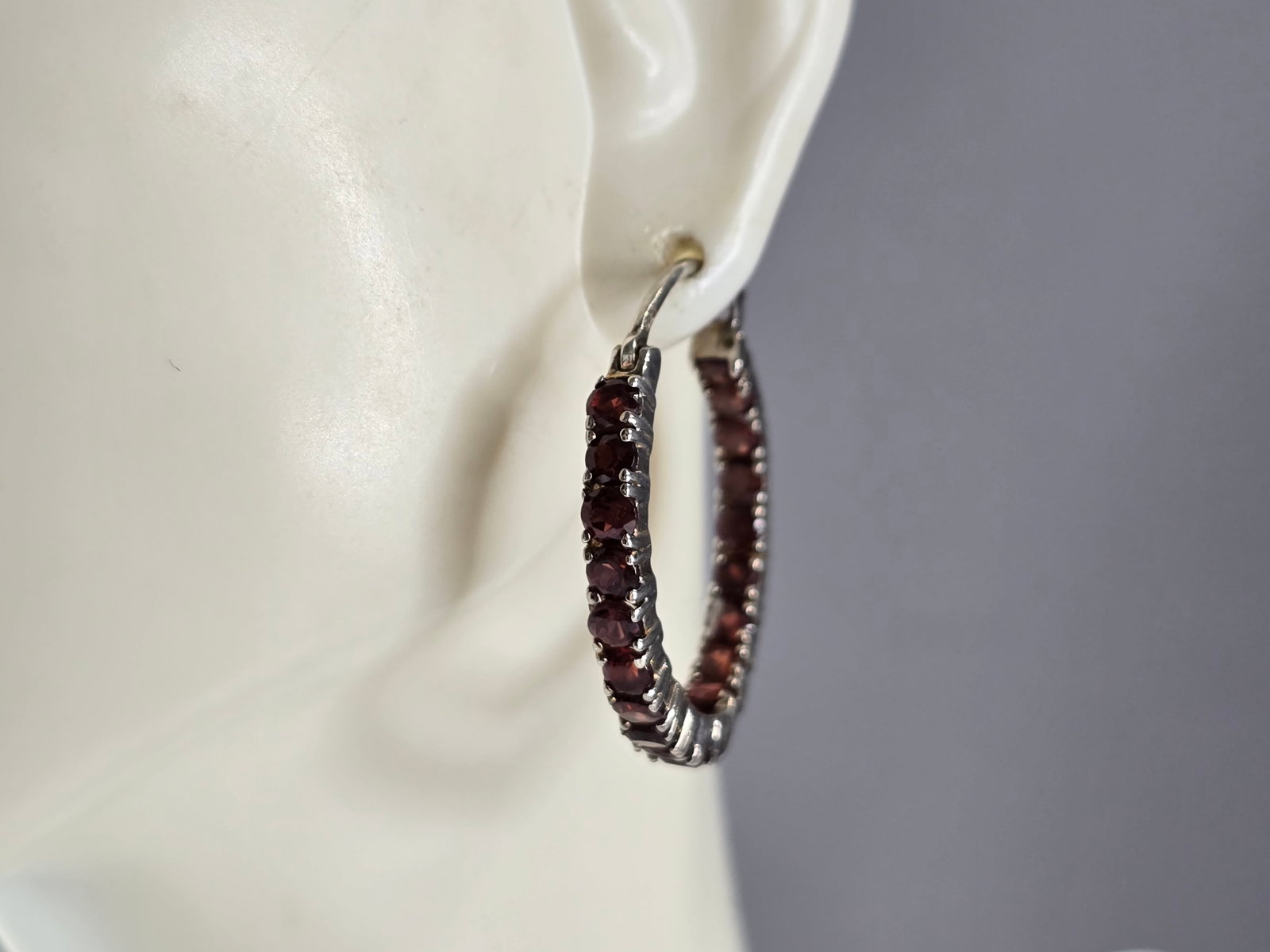 Womens Vintage Estate Sterling Silver Garnet Hoop Earrings: A PAIR OF WOMEN'S VINTAGE ESTATE STERLING SILVER HOOP EARRINGS WITH GARNET COLORED STONES. THE EARRINGS MEASURE 1" BY 1", AND WEIGH 6.9g. NOT SURE IF THE STONES ARE NATURAL OR MAN MADE. WOULD MAKE A G