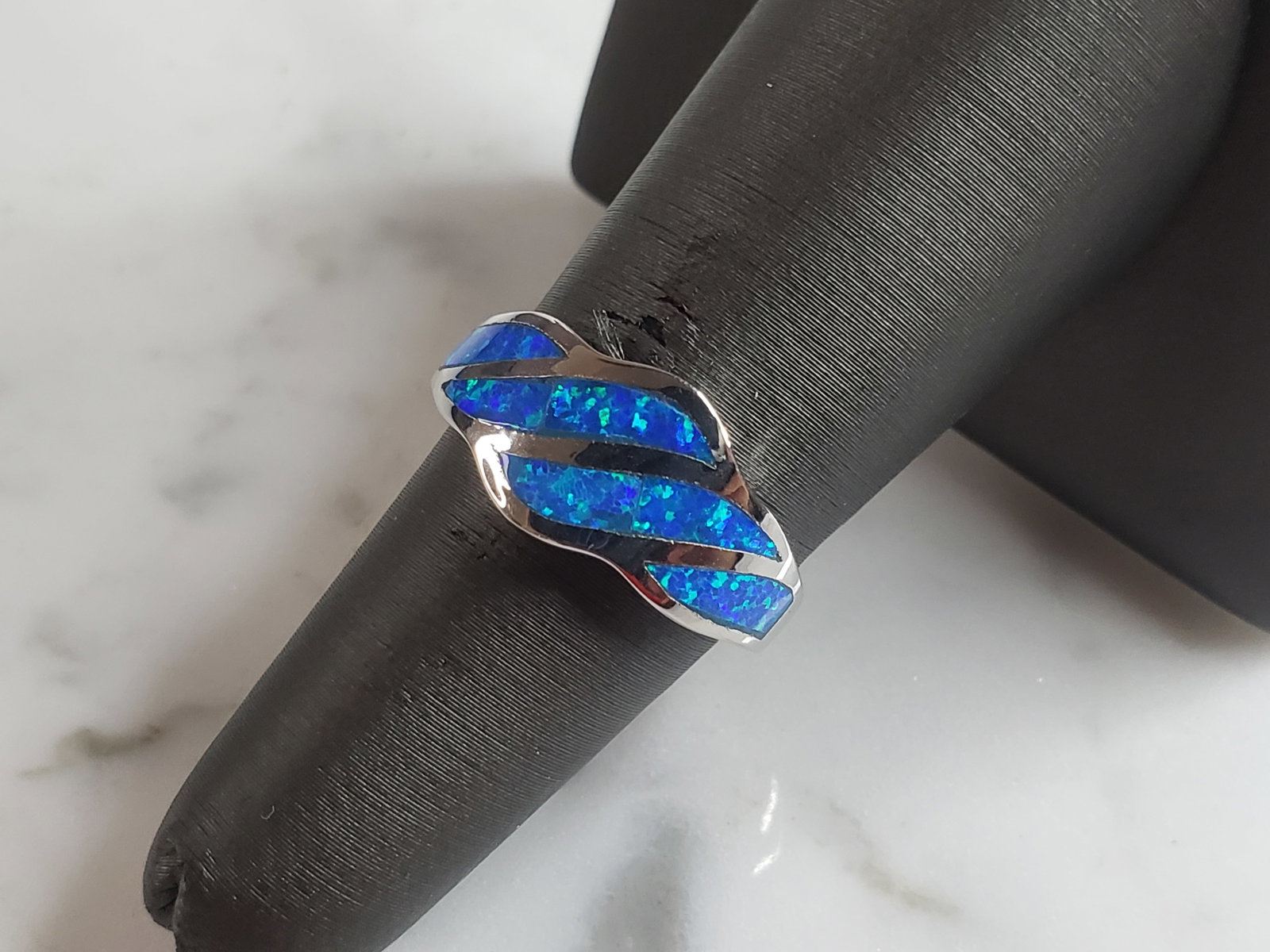 Womens Estate Sterling Silver Modernist Blue Opal Ring: A WOMENS ESTATE STERLING SILVER MODERNIST BLUE OPAL COLORED RING. THE RING IS A SIZE 6.0 AND WEIGHS 4.1g. WIDTH OF RING MEASURES 3/8". NOT SURE IF STONE IS NATURAL OR MAN MADE. THE RING MAKES A BEAUTI