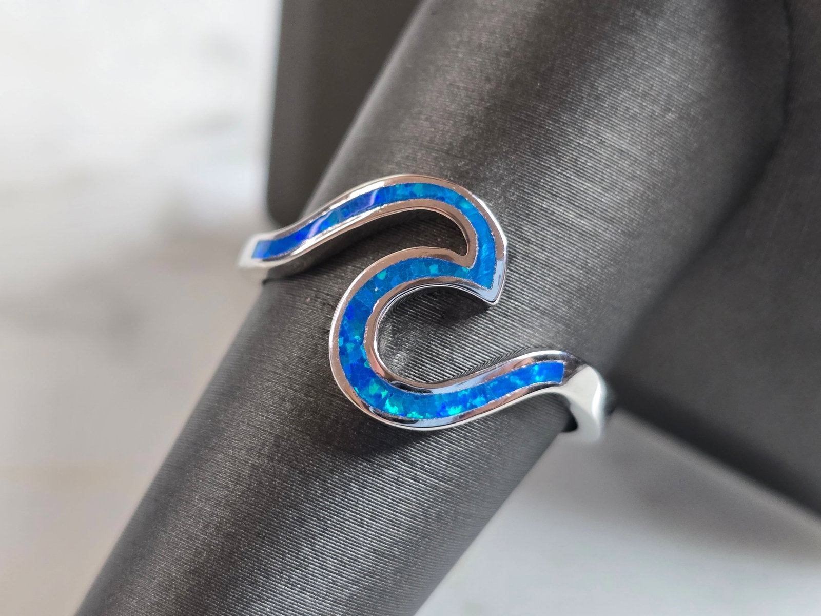 Womens Estate Sterling Silver Modernist Blue Opal Wave Ring: A WOMENS ESTATE STERLING SILVER MODERNIST BLUE OPAL COLORED WAVE RING. THE RING IS A SIZE 9.0 AND WEIGHS 3.1g. WIDTH OF RING MEASURES 1/2". NOT SURE IF STONE IS NATURAL OR MAN MADE. THE RING MAKES A B