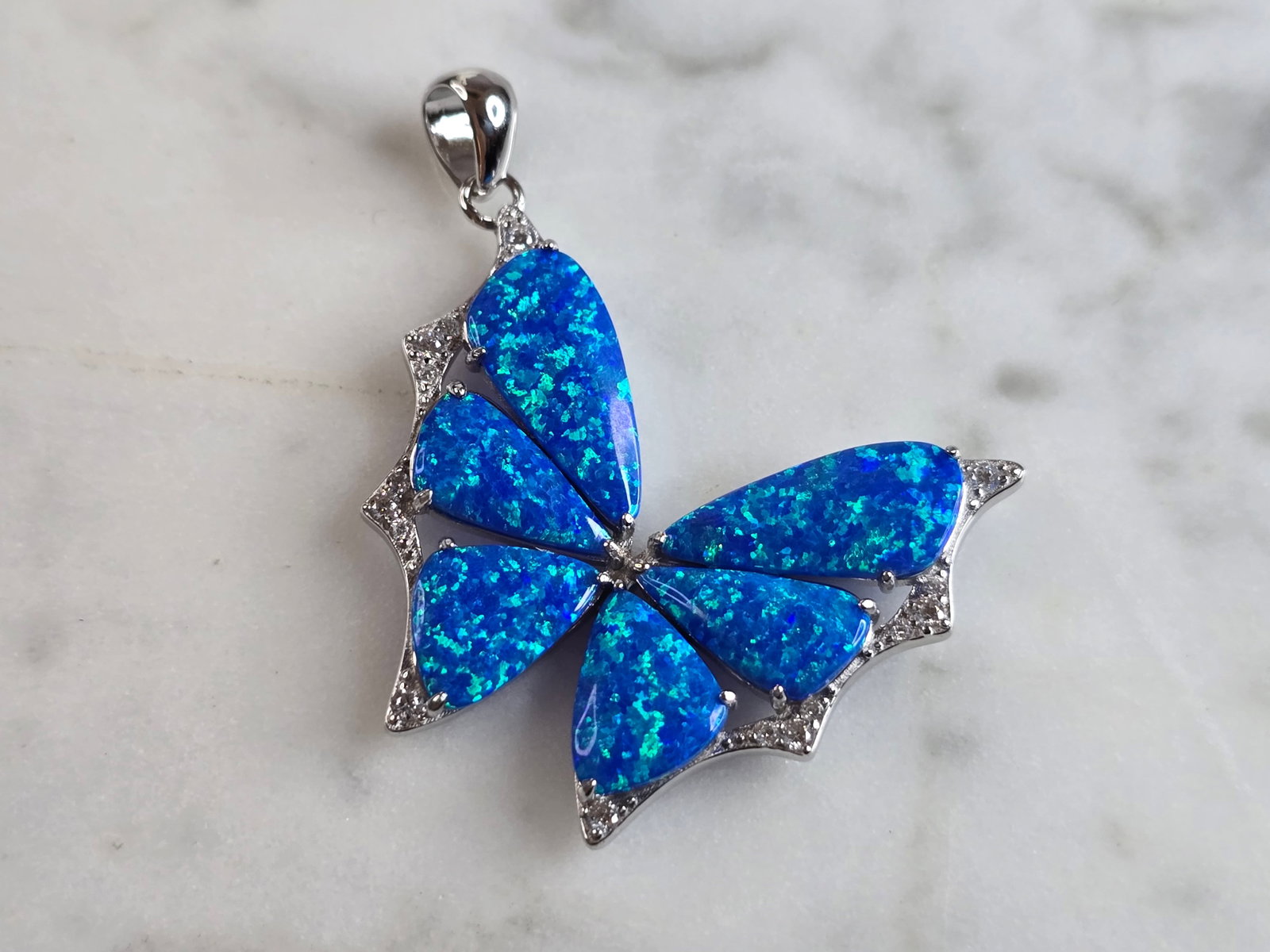 Womens Sterling Silver Blue Opal Butterfly Pendant: A WOMENS ESTATE STERLING SILVER BLUE OPAL BUTTERFLY PENDANT. NOT SURE IF STONES ARE REAL OR MAN MADE. THE PENDANT WEIGHS 3.7g, AND MEASURES 1 1/4" LONG BY 1" WIDE. MAKES A GREAT GIFT FOR THAT SOMEONE 