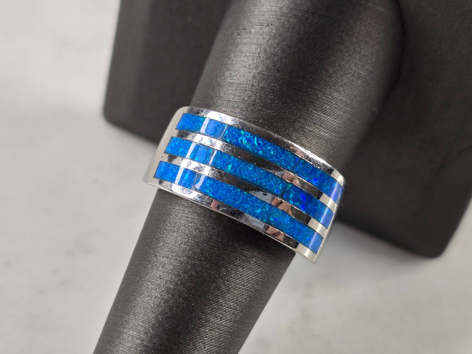 Womens Sterling Silver Modernist Blue Opal Ring: A WOMENS STERLING SILVER MODERNIST BLUE OPAL COLORED RING. THE RING IS A SIZE 5.0, AND WEIGHS 7.1g. WIDTH OF RING MEASURES 3/8". NOT SURE IF STONE IS NATURAL OR MAN MADE. THE RING MAKES A BEAUTIFUL GI