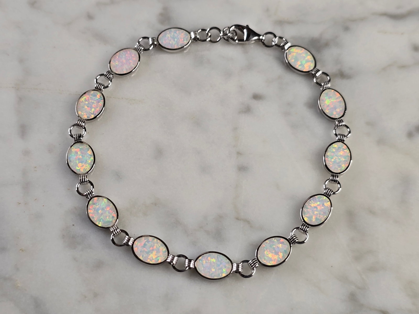 Womens Estate Sterling Silver Opal Modernist Bracelet: A WOMENS ESTATE STERLING SILVER MODERNIST OPAL COLORED BRACELET. THE BRACELET WEIGHS 6.5g AND MEASURES 7 1/2" LONG BY 1/4" WIDE. NOT SURE IF OPAL IS NATURAL OR MAN MADE. ANY QUESTIONS PLEASE DO NOT HE