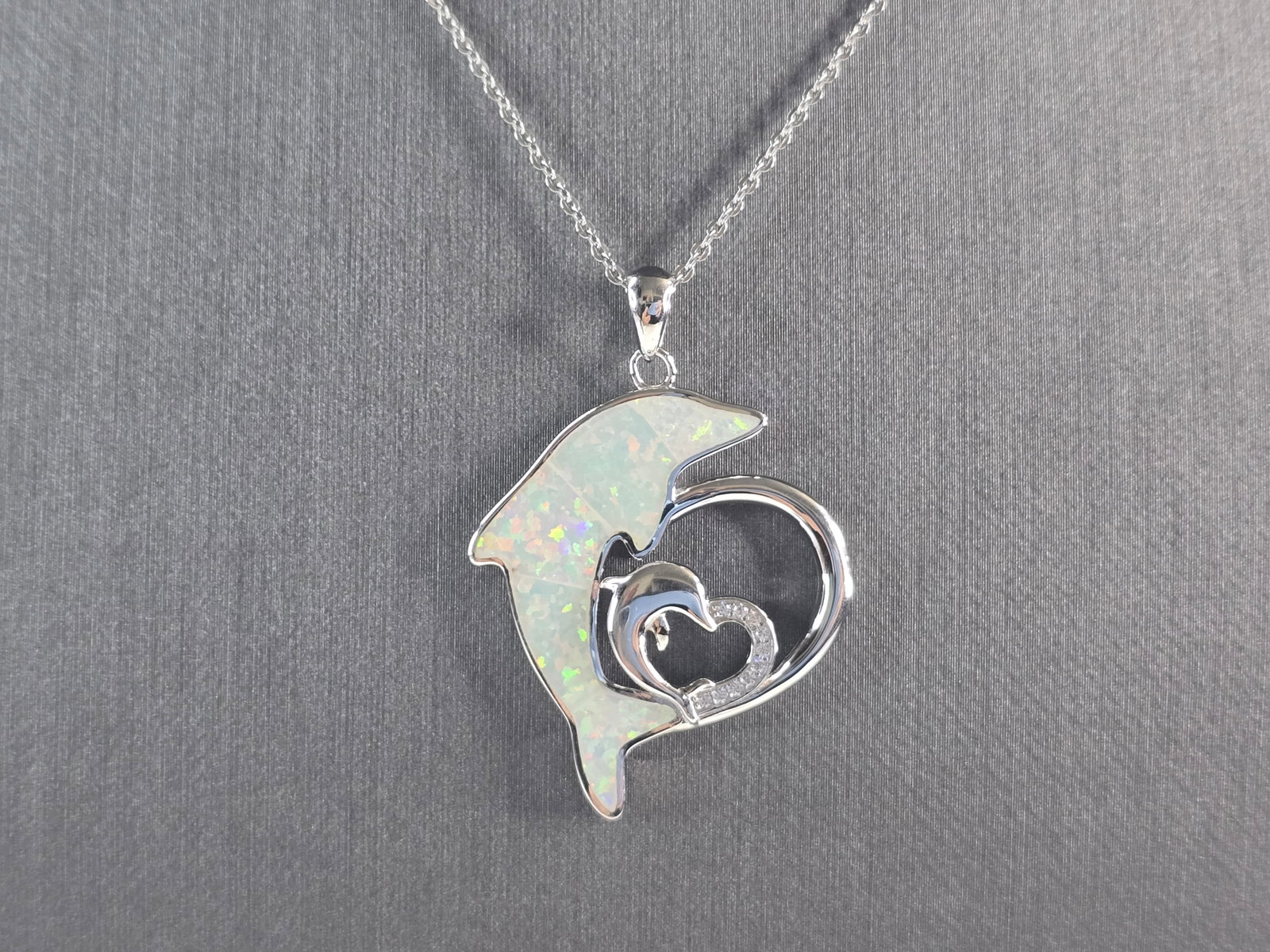 Womens Sterling Silver Opal Dolphin Pendant Necklace: A WOMENS STERLING SILVER OPAL DOLPHIN PENDANT WITH NECKLACE. THE PENDANT WITH NECKLACE WEIGHS 8.5g. PENDANT MEASURES 1 1/2" LONG BY 1" WIDE, AND THE NECKLACE MEASURES 18" LONG, ADJUSTABLE TO 16". NOT 
