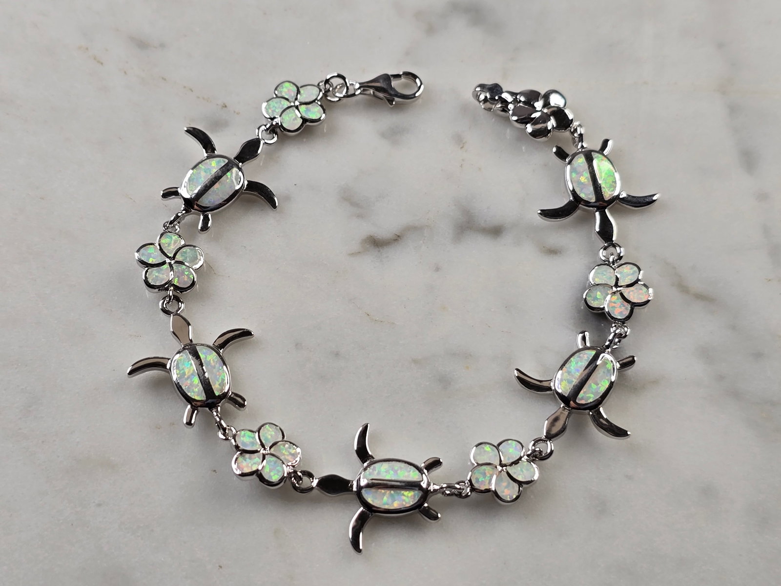 Womens Estate Sterling Silver Opal Sea Turtle Bracelet: A WOMENS ESTATE STERLING SILVER MODERNIST OPAL COLORED SEA TURTLE BRACELET. THE BRACELET WEIGHS 10.3g AND MEASURES 7" LONG BY 5/8" WIDE. NOT SURE IF OPAL IS NATURAL OR MAN MADE. ANY QUESTIONS PLEASE D