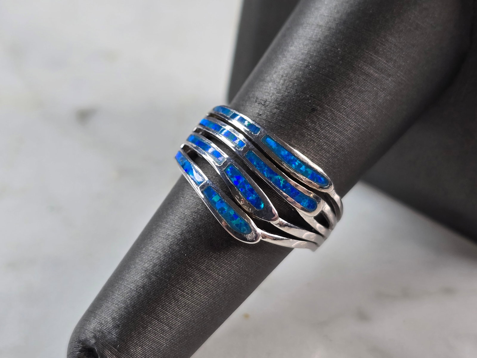 Womens Sterling Silver Modernist Blue Opal Ring: A WOMENS STERLING SILVER MODERNIST BLUE OPAL COLORED RING. THE RING IS A SIZE 6.0, AND WEIGHS 5.1g. THE WIDTH OF RING MEASURES 1/2". NOT SURE IF STONE IS NATURAL OR MAN MADE. THE RING MAKES A BEAUTIFU