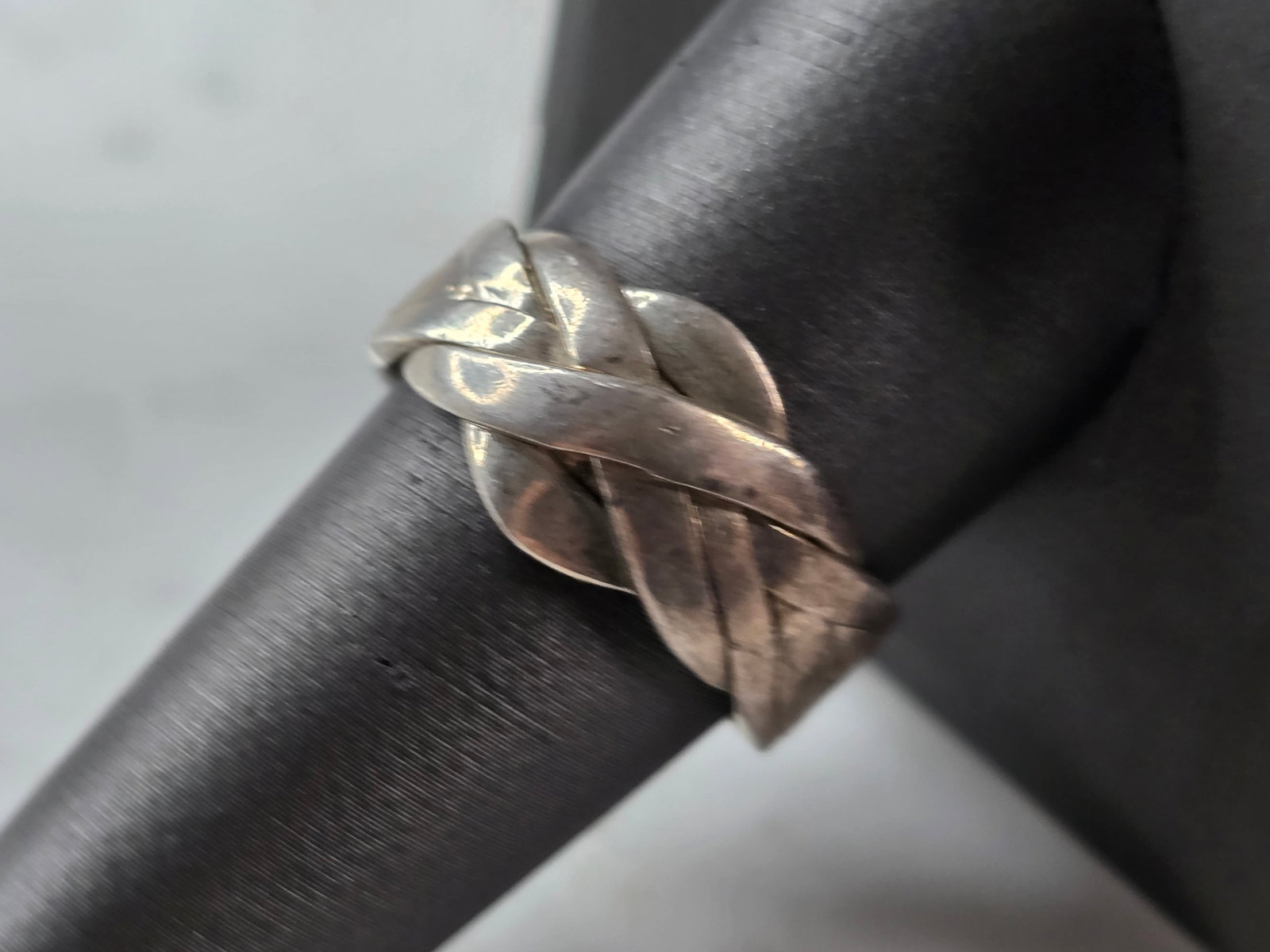 Womens Vintage Estate Sterling Silver Modernist Puzzle Ring: A WOMENS VINTAGE ESTATE STERLING SILVER MODERNIST PUZZLE RING. THE RING SIZE IS A 9.75, AND WEIGHS 6.3g. THE WIDTH OF THE RING IS 1/2". AS YOU CAN SEE THERE IS A TINY STRAP THAT KEEPS THE BAND TOGETHE