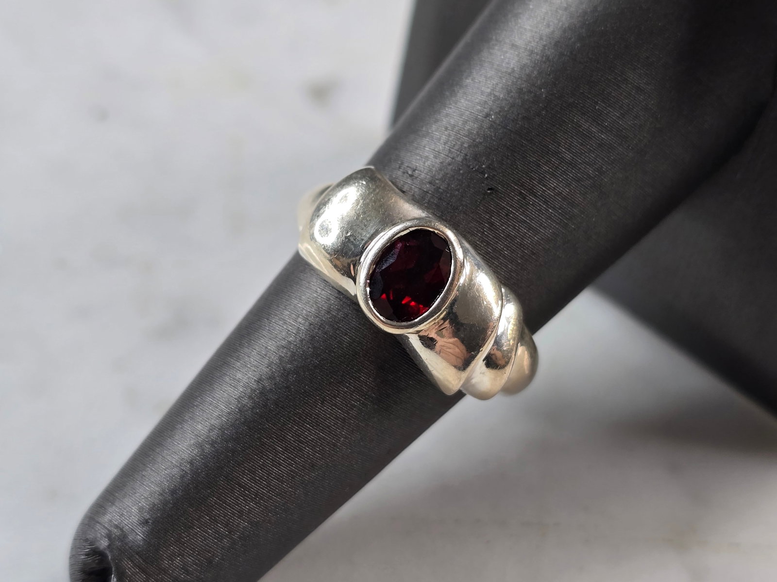 Womens Vintage Estate Sterling Silver Garnet Ring: A WOMENS VINTAGE ESTATE STERLING SILVER GARNET RING. THE RING WEIGHS 4.4g, AND MEASURES 3/8" WIDE. THE SIZE OF THE RING IS A 7.25. RING IS MARKED ON THE INSIDE OF THE BAND. NOT SURE IF THE STONE IS NA