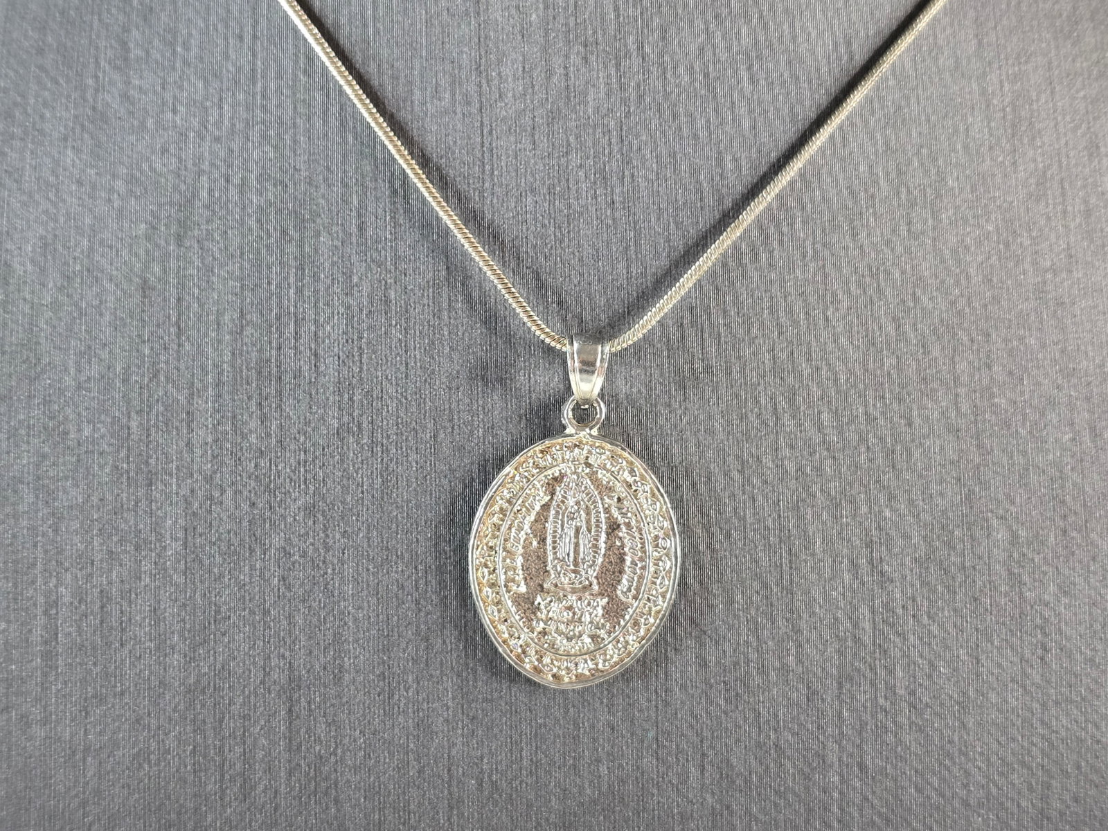 Womens Sterling Silver Religious Lady of Guadalupe Pendant Necklace: A WOMENS STERLING SILVER RELGIOUS OUR LADY OF GUADALUPE PENDANT WITH NECKLACE . THE TOTAL WEIGHT IS 7.9g. THE PENDANT MEASURES 1 1/8" LONG BY 3/4" WIDE. THE NECKLACE MEASURES 18 3/4" LONG. MAKES A GRE
