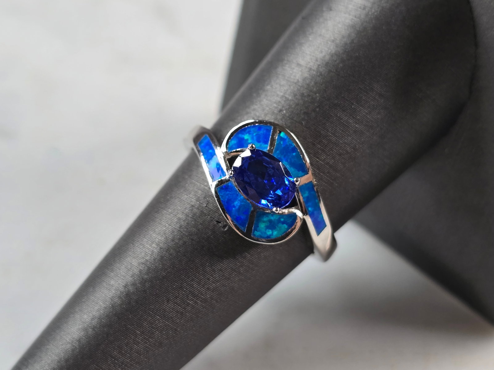 Womens Sterling Silver Blue Opal Tanzanite Ring: A WOMENS STERLING SILVER BLUE OPAL & TANZANITE COLORED RING. THE RING IS A SIZE 8.0, AND WEIGHS 3.5g. WIDTH OF RING MEASURES 3/8". NOT SURE IF STONE IS NATURAL OR MAN MADE. THE RING MAKES A BEAUTIFUL 