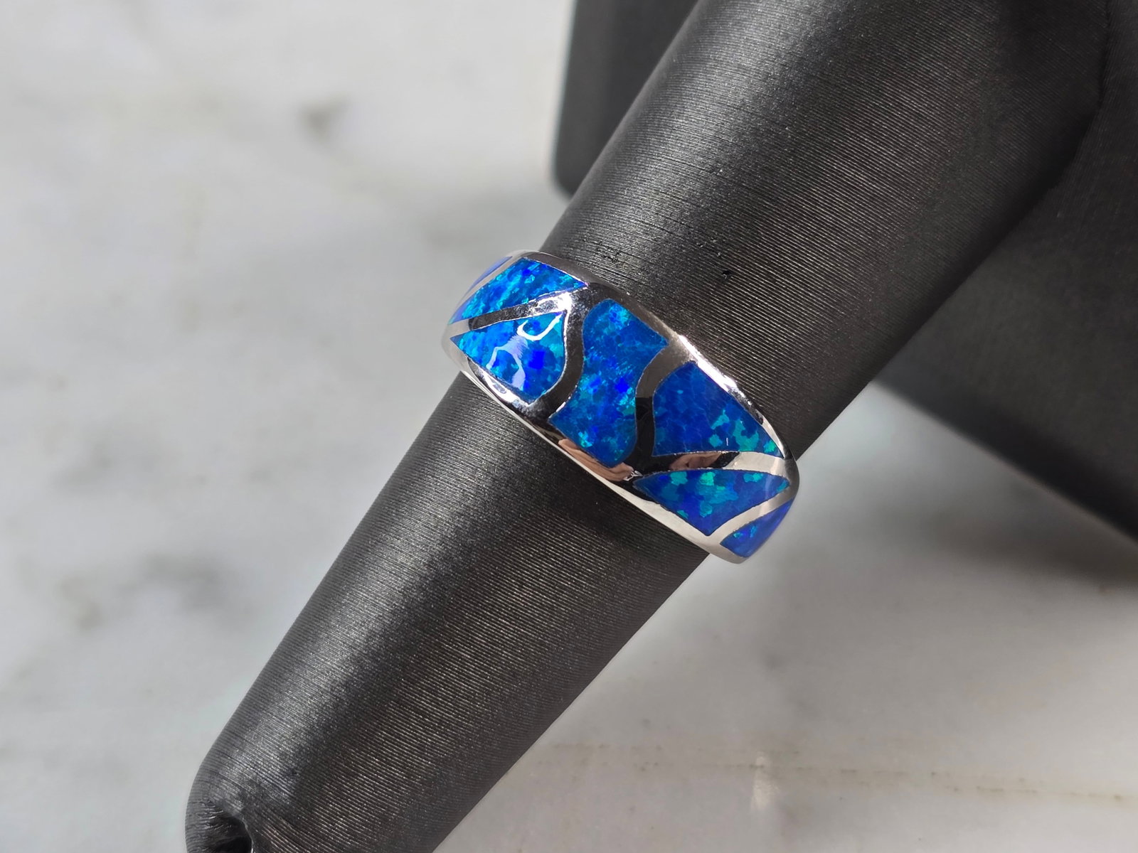 Womens Sterling Silver Modernist Blue Opal Ring: A WOMENS STERLING SILVER MODERNIST BLUE OPAL COLORED RING. THE RING IS A SIZE 7.0 AND WEIGHS 4.9g. WIDTH OF RING MEASURES 3/8". NOT SURE IF STONE IS NATURAL OR MAN MADE. THE RING MAKES A BEAUTIFUL GIF