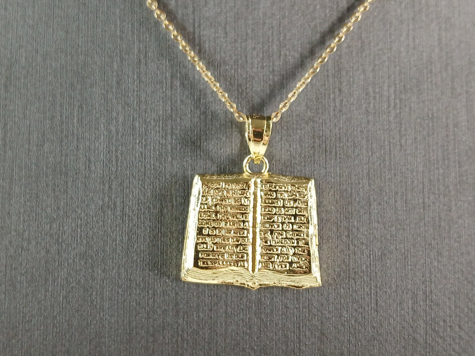 Sterling Silver Gold Tone Religious Holy Bible Pendant Necklace: A STERLING SILVER GOLD TONE RELIGIOUS HOLY BIBLE PENDANT WITH NECKLACE. PENDANT WITH NECKLACE WEIGHS 3.7g. THE PENDANT MEASURES 1" LONG BY 7/8" WIDE. THE NECKLACE MEASURES 18" LONG AND IS ADJUSTABLE T