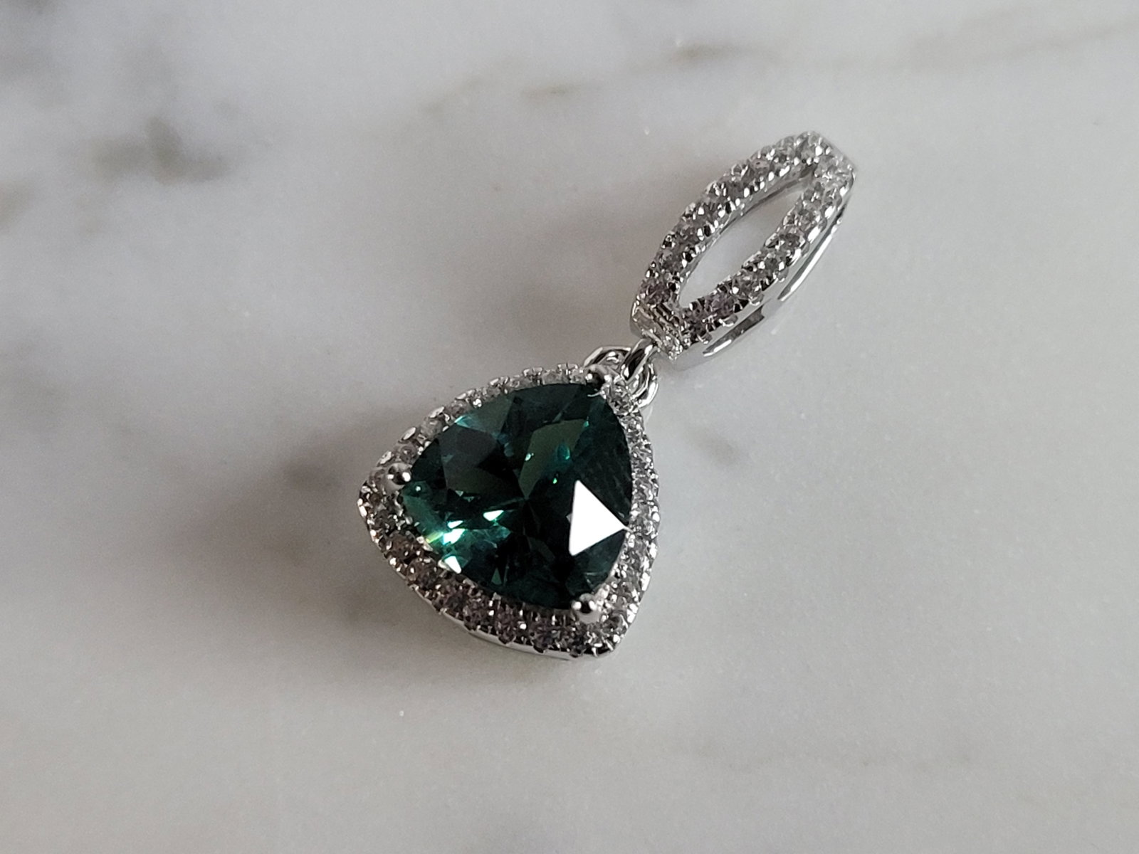 Womens Sterling Silver Modernist CZ Pendant: A WOMENS STERLING SILVER MODERNIST CZ PENDANT WITH AN EMERALD COLORED STONE. PENDANT WEIGHS 2.8g AND MEASURES 7/8" LONG BY 3/8" WIDE. MAKES A GREAT GIFT FOR THAT SOMEONE SPECIAL. ANY QUESTIONS, PLEASE