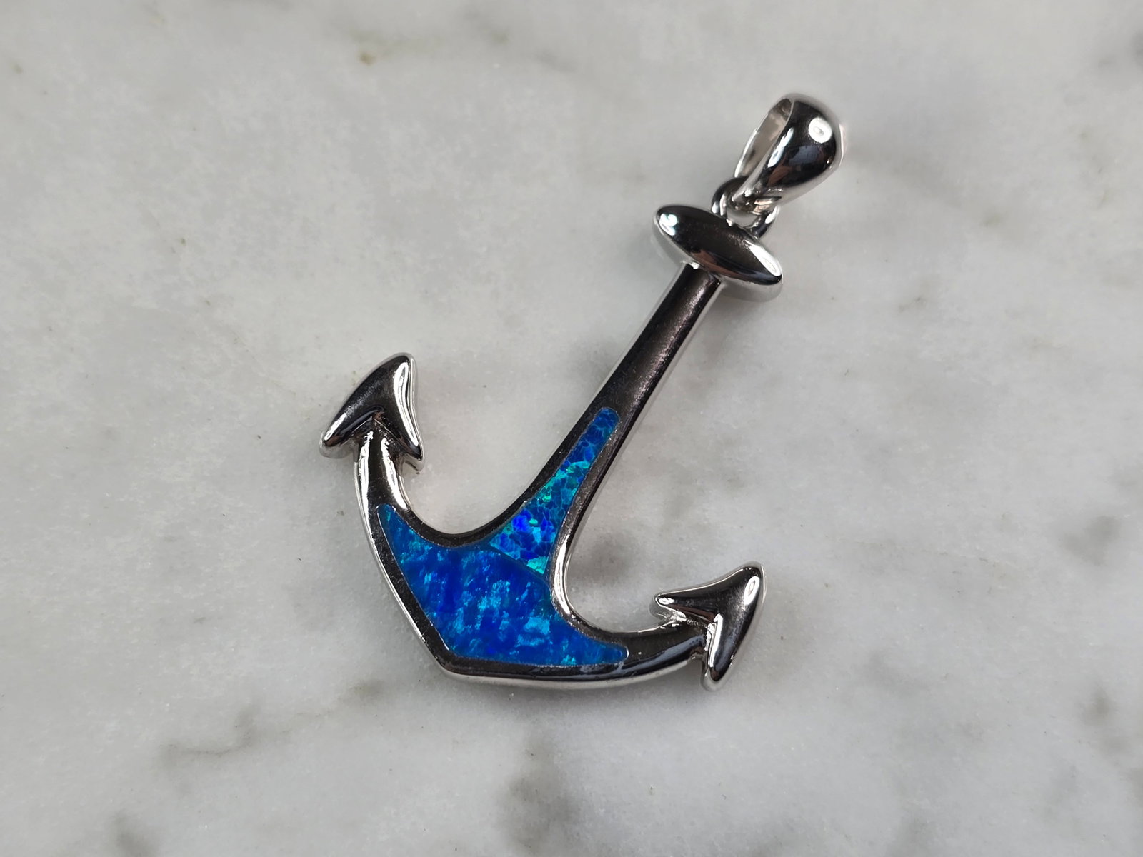 Womens Sterling Silver Blue Opal Maritime Anchor Pendant: A WOMENS STERLING SILVER BLUE OPAL MARITIME ANCHOR PENDANT. THE PENDANT WEIGHS 3.0g AND MEASURES 1 1/4" LONG BY 3/4" WIDE. NOT SURE IF STONES ARE NATURAL OR MAN MADE. MAKES A GREAT GIFT FOR THAT SOMEO