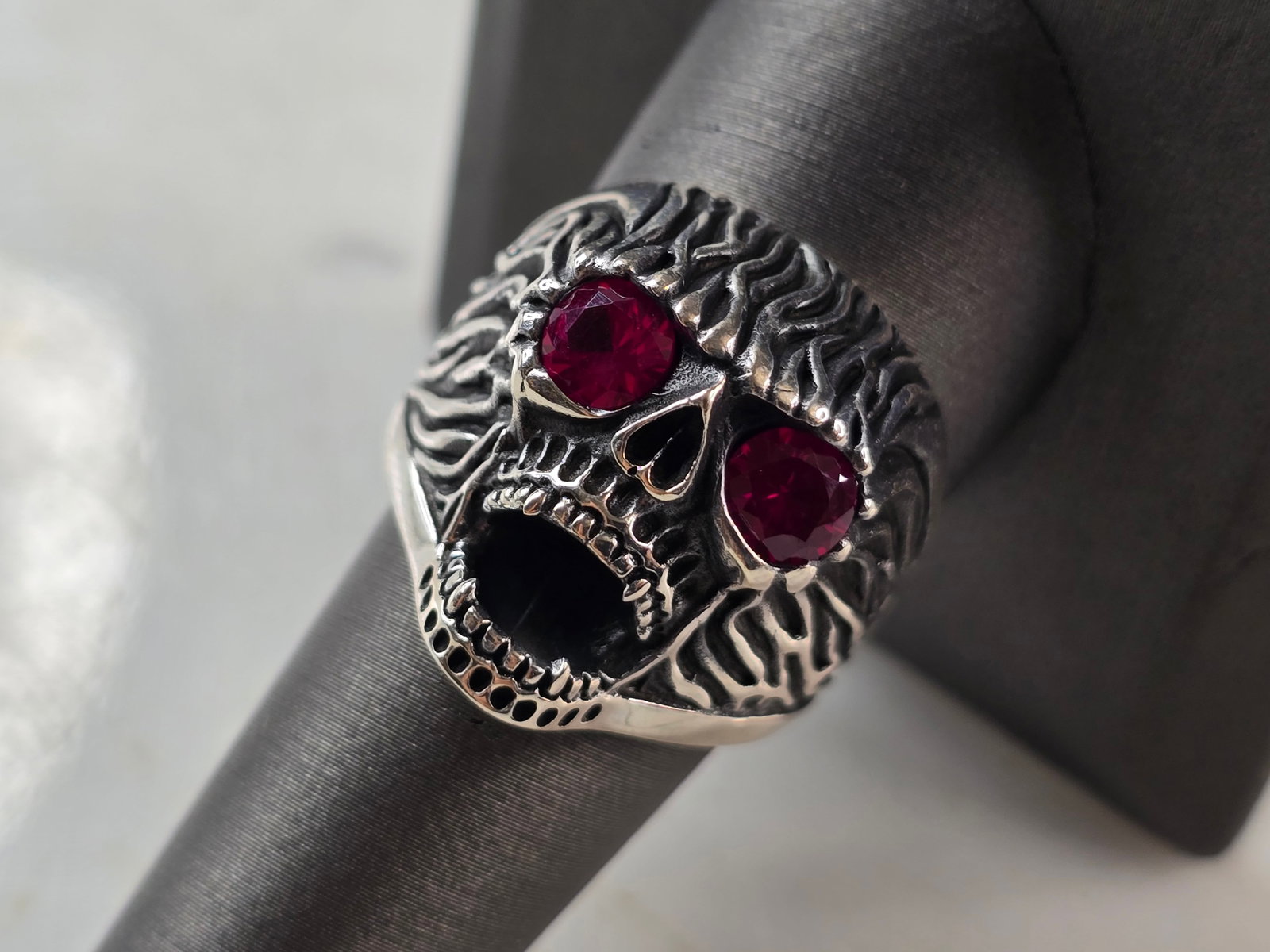 Mens Sterling Silver Ruby Eyed Skull Ring: A MENS STERLING SILVER RUBY EYED SKULL RING. THE TOTAL WEIGHT IS 14.4g, AND IS A SIZE 10.0. THE WIDTH OF THE RING FACE IS 7/8". STONES TESTED RUBY ON OUR PRESIDIUM GEM TESTER, HOWEVER NOT SURE IF THEY