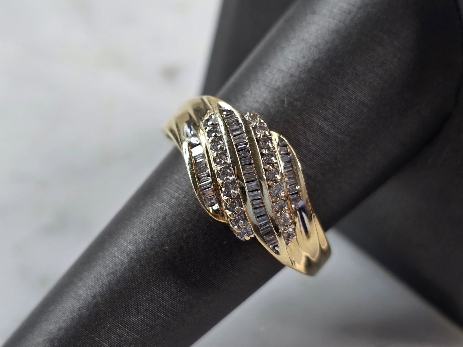 Womens Vintage Estate 10K Yellow Gold Modernist Diamond Ring: A WOMENS VINTAGE ESTATE 10K YELLOW GOLD DIAMOND RING. THERE ARE 31 BAGUETTE DIAMONDS, AND 18 TINY ROUND DIAMONDS IN THIS RING. THE TOTAL WEIGHT IS 4.0g, AND IS A SIZE 8.25. THE WIDTH OF THE RING IS 1/