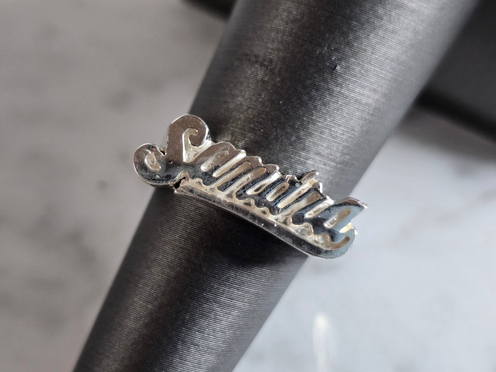 Womens Vintage Estate Sterling Silver " SANDRA" Ring: A WOMENS VINTAGE ESTATE STERLING SILVER RING WITH THE NAME "SANDRA" ON THE FACE. THE RING WEIGHS 4.1g AND IS A SIZE 6.0. THE WIDTH OF THE RING IS 1/4". THIS RING WOULD BE A WONDERFUL GIFT FOR THAT SPE