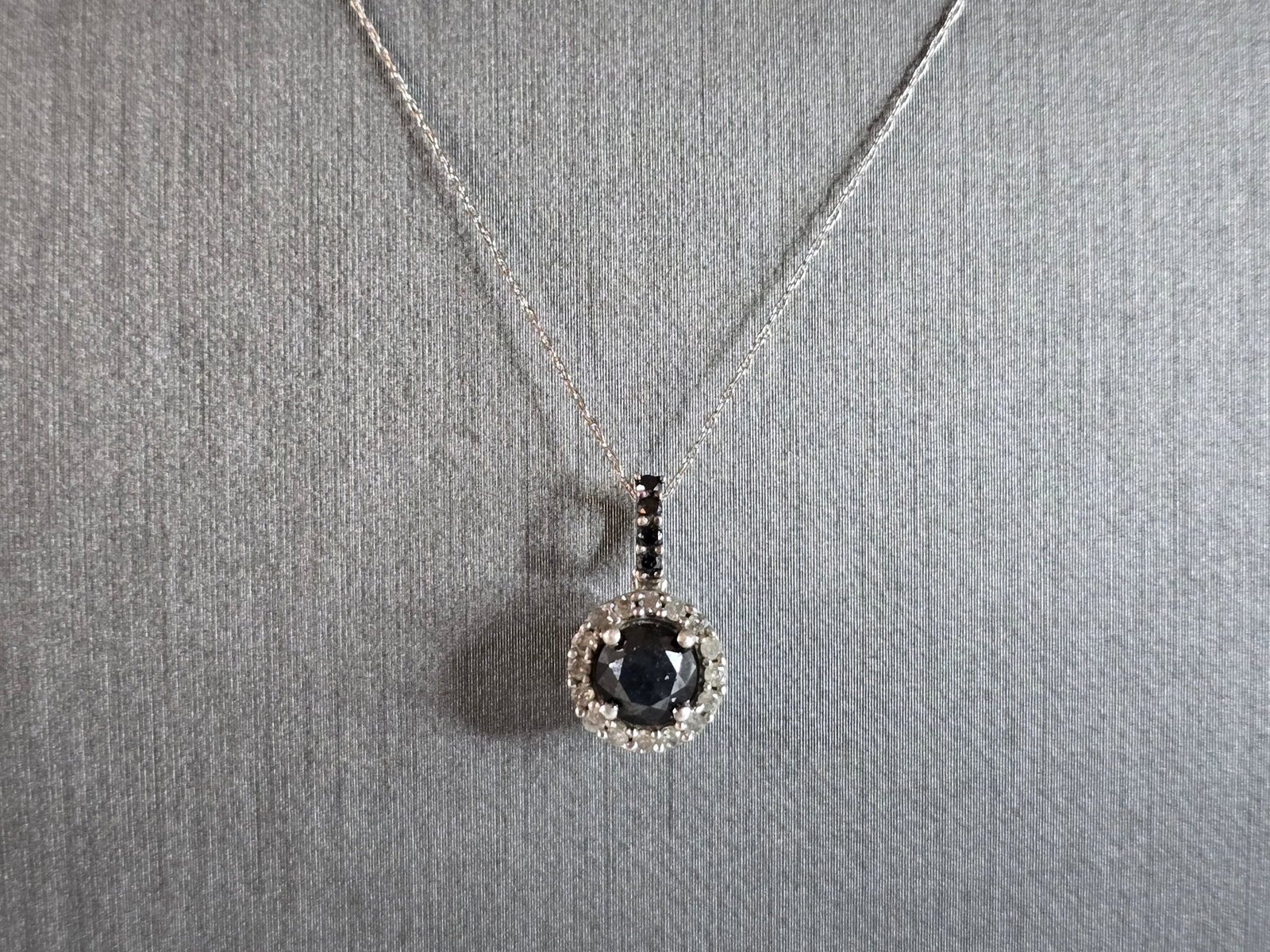Womens Vintage Estate 10K White Gold Black Diamond Pendant Necklace: A WOMENS VINTAGE ESTATE 10K WHITE GOLD PENDANT WITH BLACK & WHITE DIAMONDS. NECKLACE MEASURES 21 1/2" LONG AND THE PENDANT MEASURES 5/8" BY 3/8". THE TOTAL WEIGHT IS 2.1g. CENTER DIAMOND IS ABOUT .85c