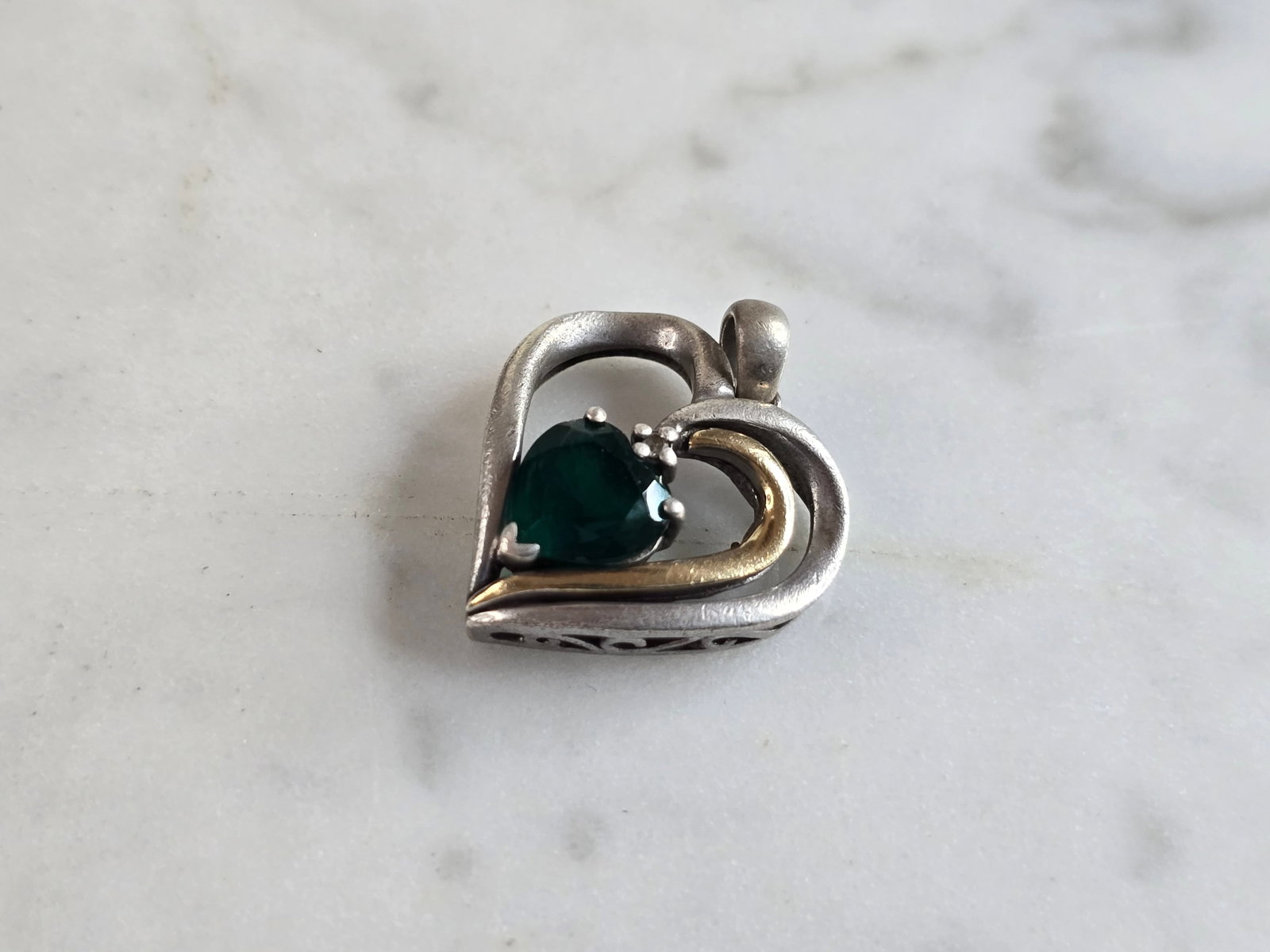 Womens Vintage Estate Sterling Silver 14k Gold Heart Pendant: A WOMENS VINTAGE ESTATE STERLING SILVER WITH 14K GOLD HEART PENDANT. PENDANT HAS AN EMERALD LIKE COLORED STONE. THE PENDANT WEIGHS 2.8g, AND MEASURES 3/4" WIDE BY 7/8" LONG. MAKES A GREAT GIFT FOR THA