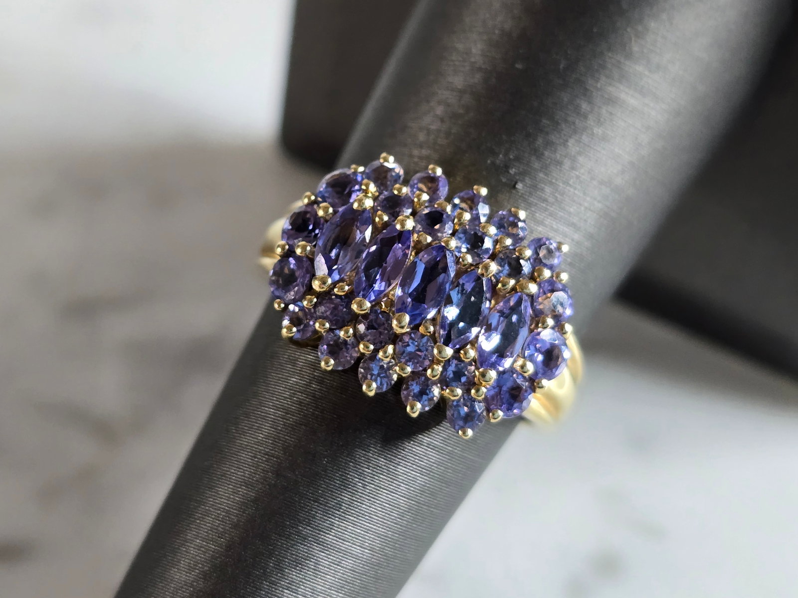 Womens Vintage Estate 14k Yellow Gold Tanzanite Ring: A WOMEN'S VINTAGE ESTATE 14K GOLD RING WITH WHAT APPEARS TO BE TANZANITE COLORED STONES. NOT SURE IF THEY NATURAL OR MAN MADE. THE RING WEIGHS 4.3g, AND IS A SIZE 7.0. THE WIDTH OF THE RING IS 1/2". A