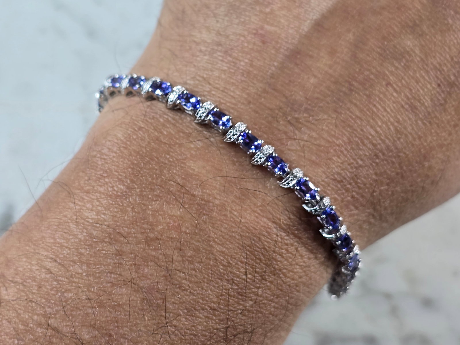 Womens Vintage Estate Sterling Silver Tanzanite Bracelet: A WOMENS VINTAGE ESTATE STERLING SILVER TANZANITE COLORED BRACELET. BRACELET MEASURES 7" LONG BY 1/8" WIDE, AND WEIGHS 10.1g. NOT SURE IF STONES ARE NATURAL OR MAN MADE. THIS WOULD MAKE A LOVELY GIFT 