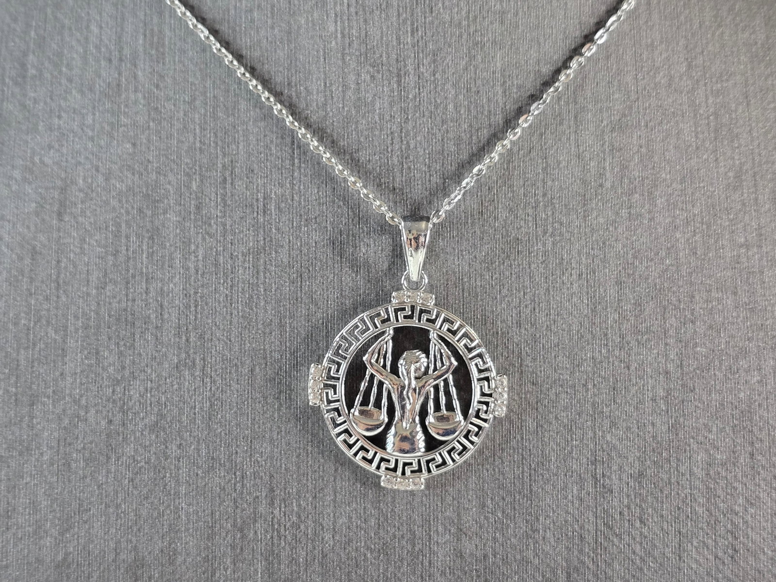 Womens Sterling Silver Libra Zodiac Pendant Necklace: A WOMENS VINTAGE ESTATE STERLING SILVER LIBRA ZODIAC PENDANT WITH NECKLACE. PENDANT WITH NECKLACE WEIGHS 3.3g. PENDANT MEASURES 1 1/4" LONG BY 7/8" WIDE. THE NECKLACE MEASURES 18" LONG. MAKES A GREAT 
