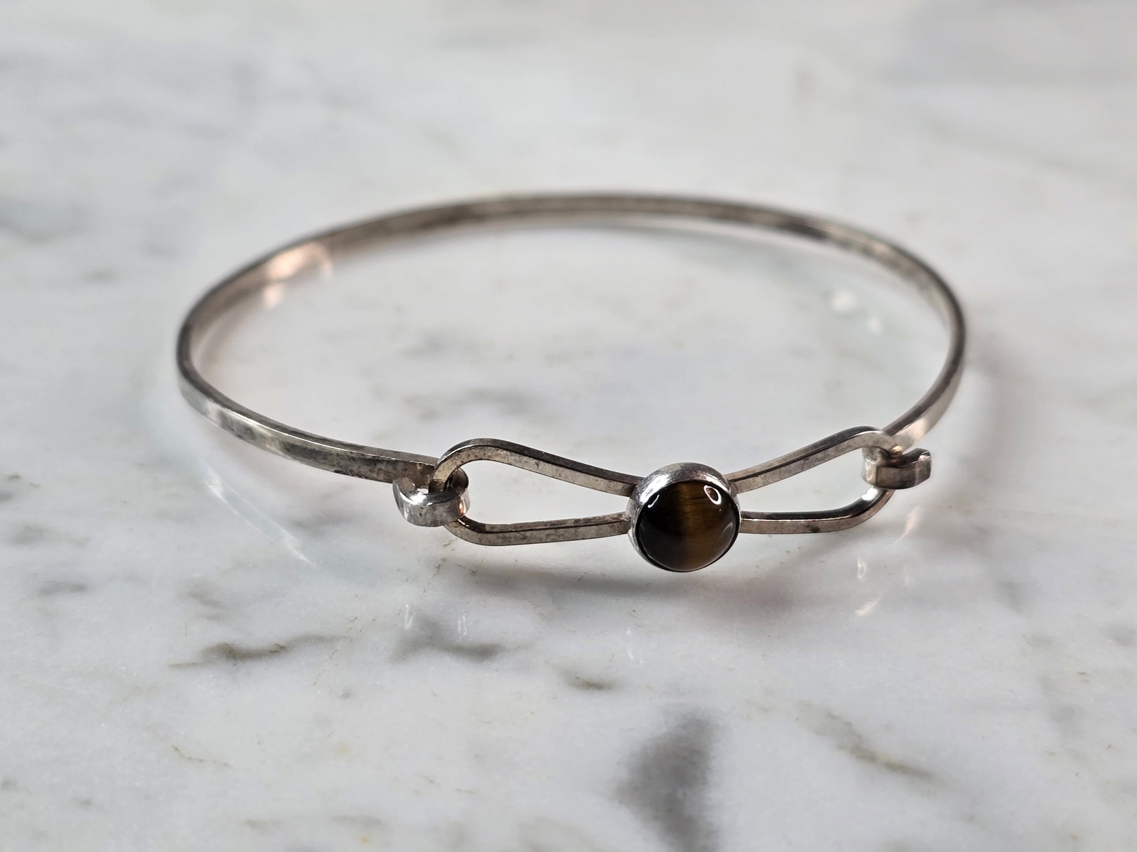 Womens Vintage Estate Sterling Silver Israel Tigers Eye Bracelet: A WOMENS VINTAGE ESTATE STERLING SILVER TIGERS EYE BRACELET THAT WAS MADE IN ISRAEL. BRACELET MEASURES 7" IN CIRCUMFERENCE, BY 1/4" WIDE AND WEIGHS 5.8g. THIS WOULD MAKE A LOVELY GIFT FOR THAT SOMEONE