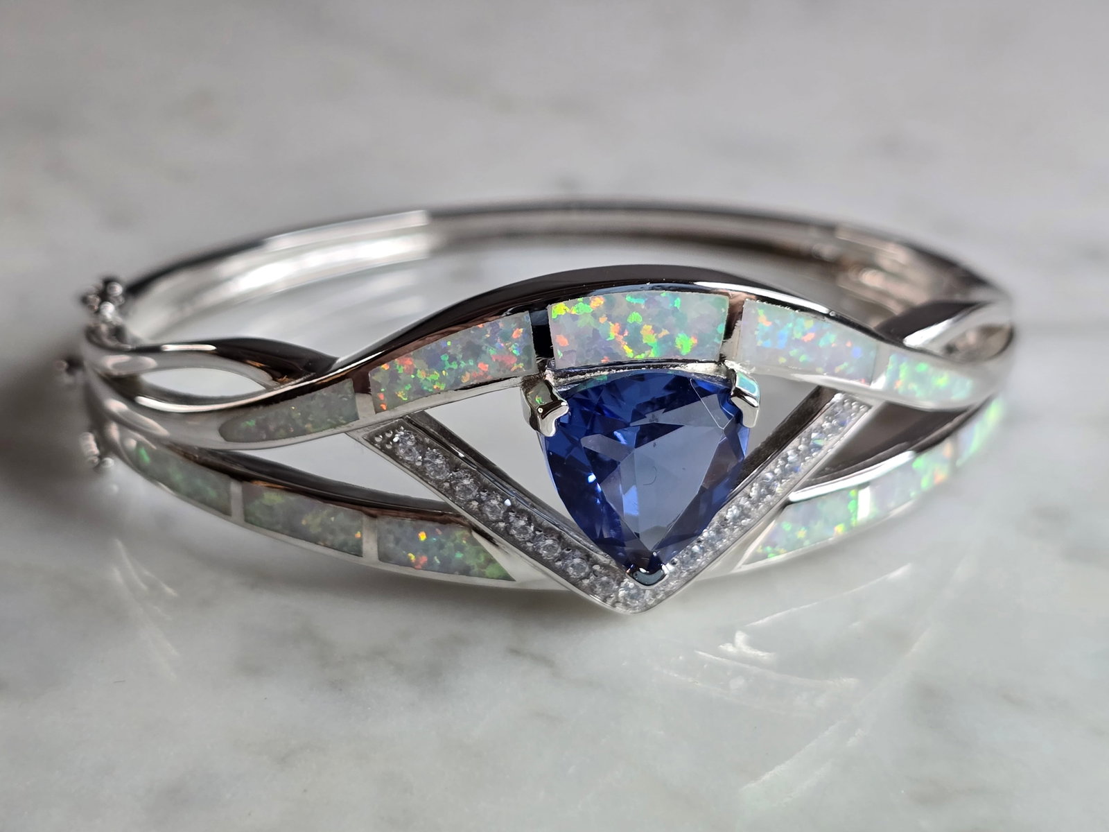 Womens Sterling Silver Modernist Opal Bangle Bracelet: A WOMENS STERLING SILVER MODERNIST OPAL COLORED BANGLE BRACELET WITH AN AQUA COLORED STONE. THE BRACELET WEIGHS 28.0g AND IS ABOUT 7/8" WIDE. THE CIRCUMFERENCE IS 7 1/4". NOT SURE IF THE OPAL IS REAL 