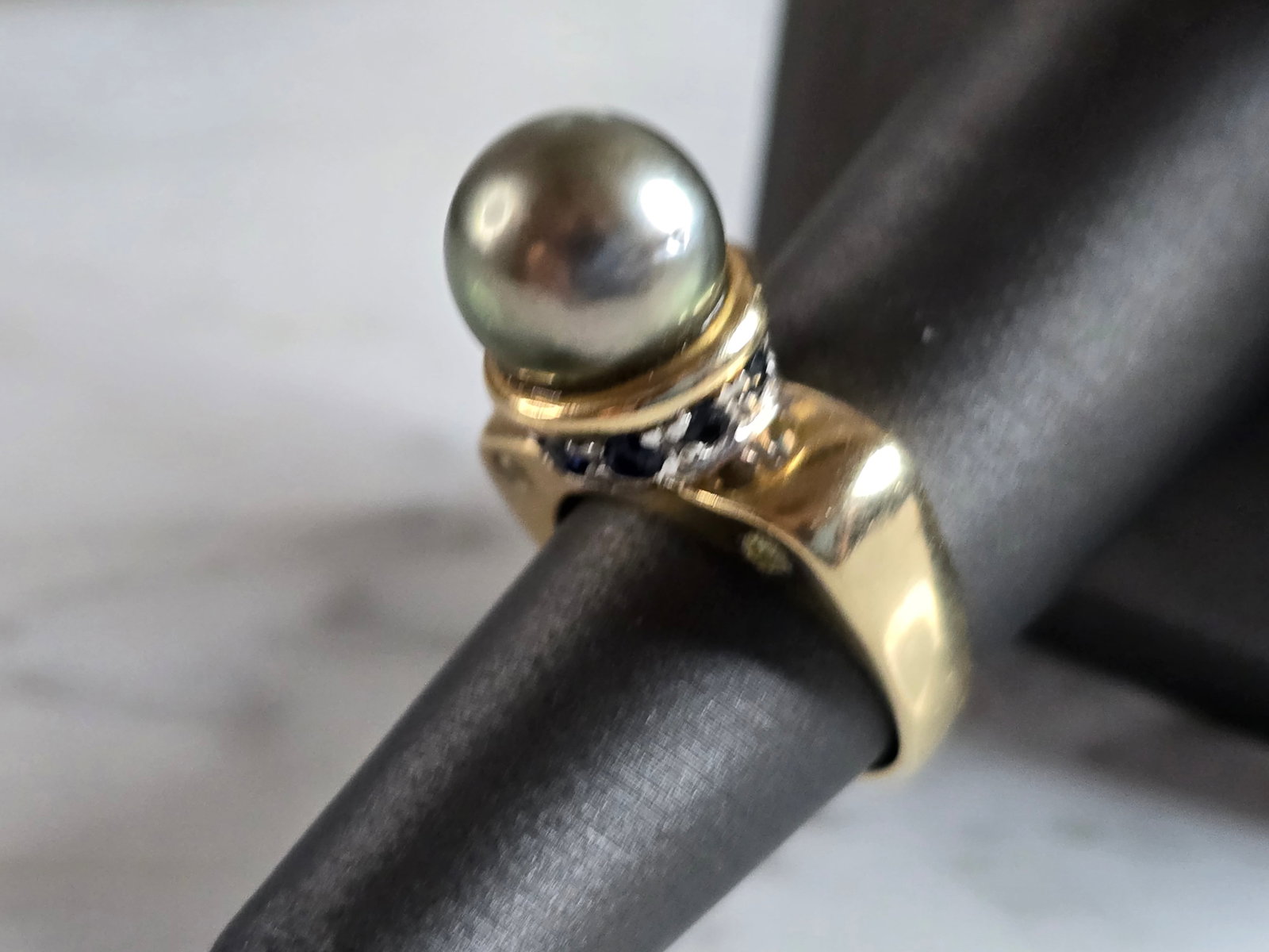 Womens Vintage Estate 14K Gold Pearl & Sapphire Ring: A WOMENS VINTAGE ESTATE 14K GOLD PEARL,SAPPHIRE & DIAMOND RING. THE RING IS A SIZE 6.5, AND WEIGHS 9.4g. NOT SURE IF THE PEARL IS REAL OR MAN MADE. DOES HAVE A GRIT FEELING. RING IS MARKED 14K, JITC. 