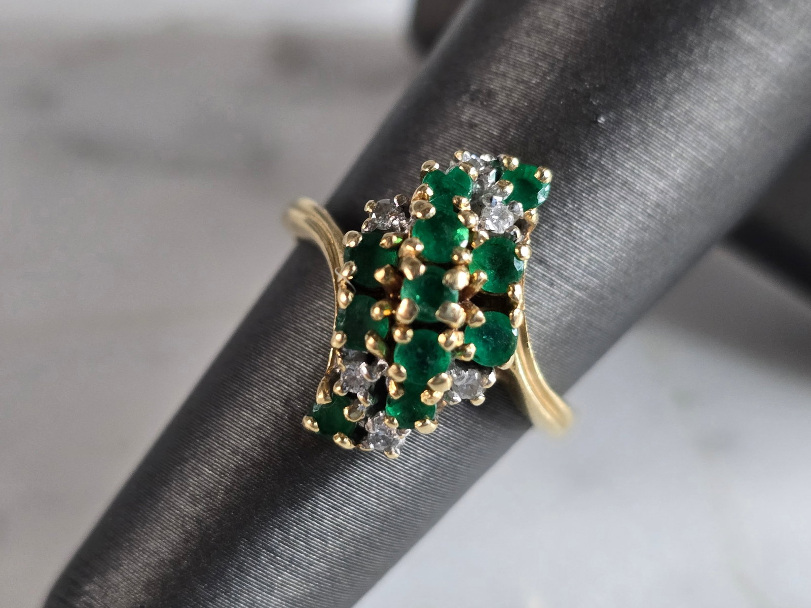 Womens Vintage Estate 14K Gold Diamond & Emerald Cluster Ring: A WOMENS VINTAGE ESTATE 14K GOLD CLUSTER RING WITH EMERALDS AND DIAMONDS. RING IS A SIZE 6.0 AND WEIGHS 4.1g. THERE ARE ABOUT .18cts OF DIAMONDS, AND ABOUT 0.33cts OF EMERALDS. THE LENGTH OF THE RING 