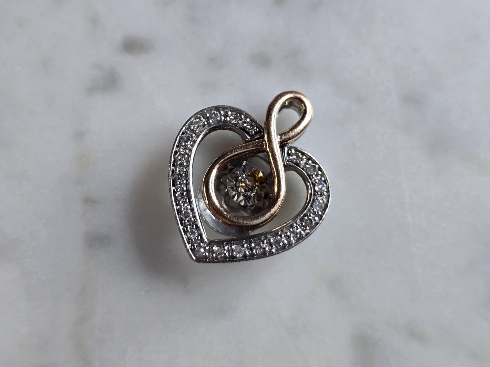Womens Vintage Sterling Silver 10k Rose Gold Diamond Heart Pendant: A WOMENS VINTAGE ESTATE STERLING SILVER, 10k ROSE GOLD DIAMOND HEART PENDANT. THE PENDANT WEIGHS 2.0g, AND MEASURES 1/2" LONG BY 1/2" WIDE. THERE ARE 22 TINY DIAMONDS IN THIS PENDANT. MAKES A GREAT GI