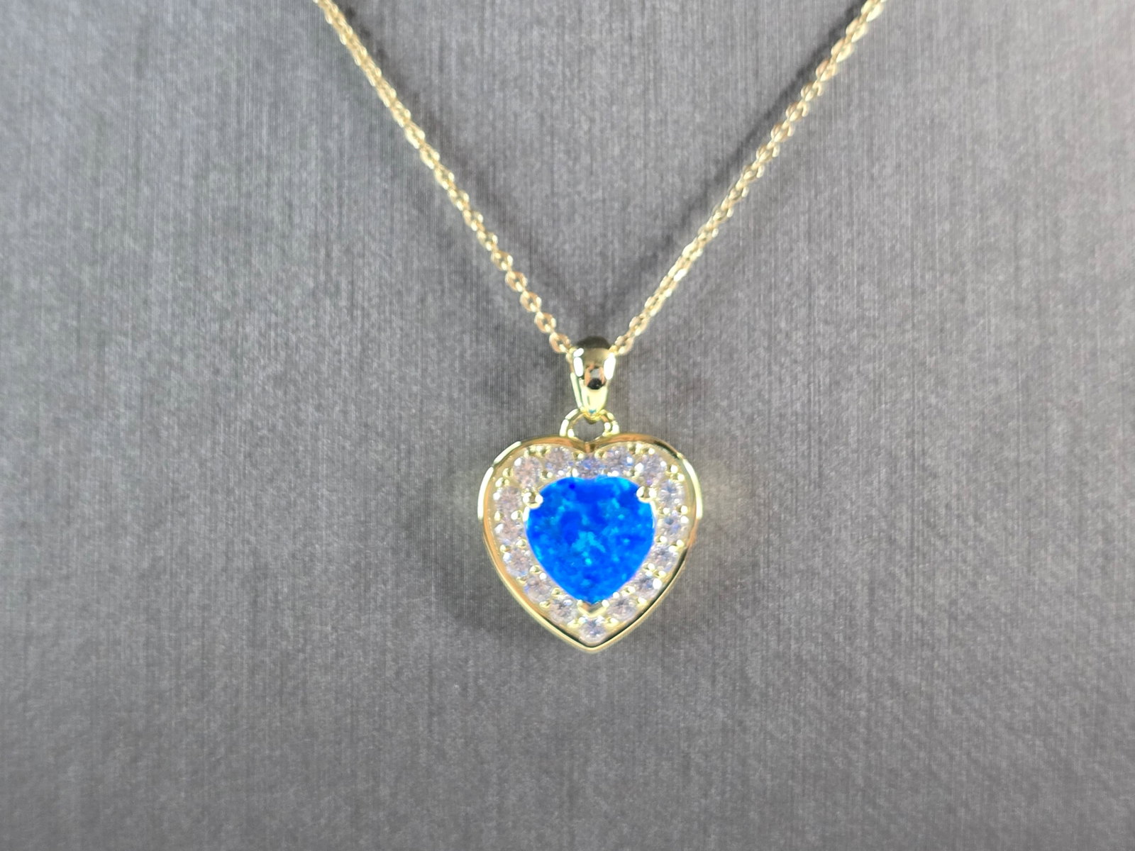 Womens Sterling Silver Gold Tone Blue Opal Heart Pendant Necklace: A WOMENS STERLING SILVER GOLD TONE BLUE OPAL HEART PENDANT. THE PENDANT WITH NECKLACE WEIGHS 5.8g. THE PENDANT MEASURES 7/8" LONG BY 5/8" WIDE, AND THE NECKLACE MEASURES 18" LONG, ADJUSTABLE TO 16" LO